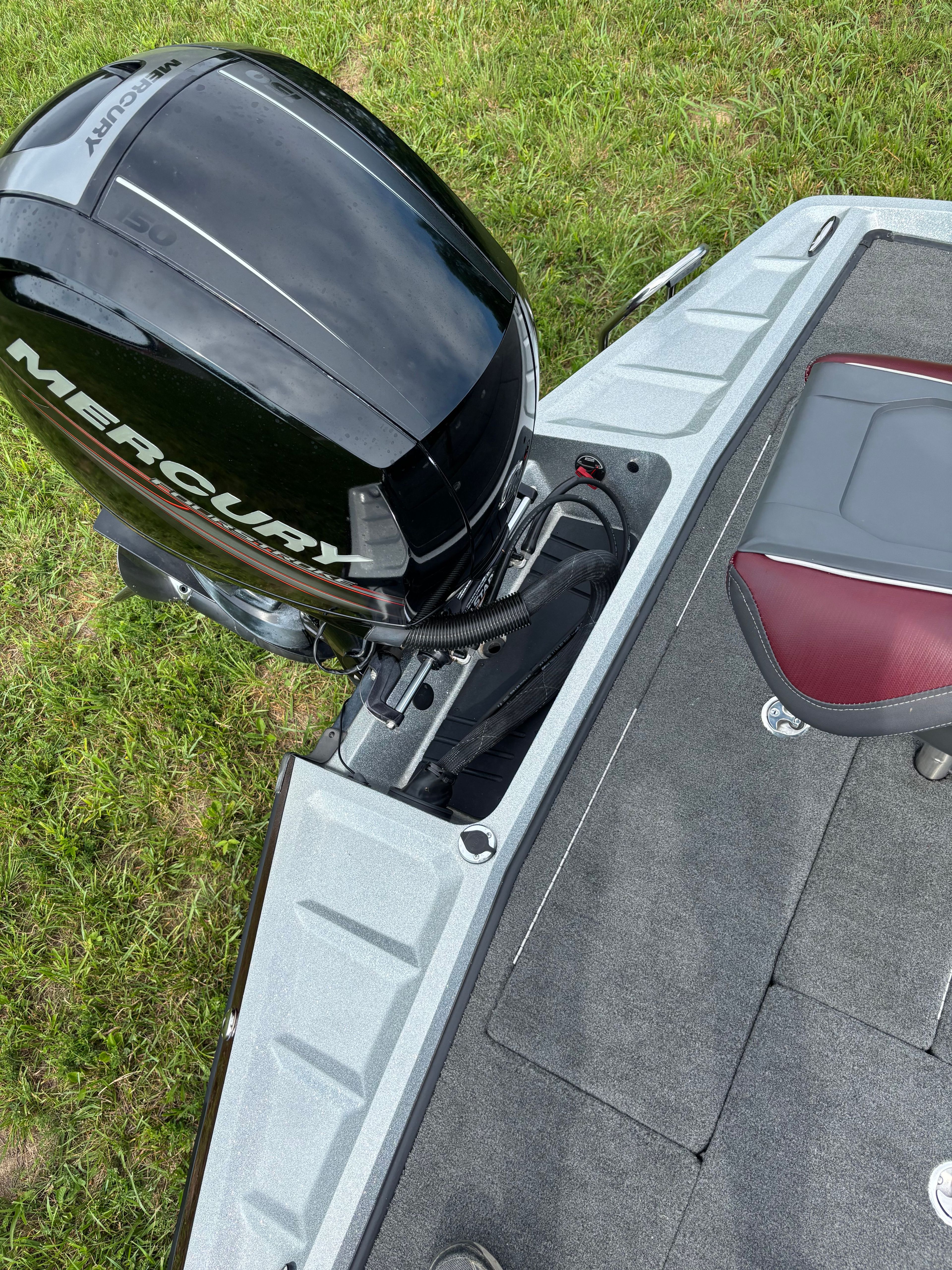 A Ranger Z 185 boat with a Mercury outboard motor, parked on grass.