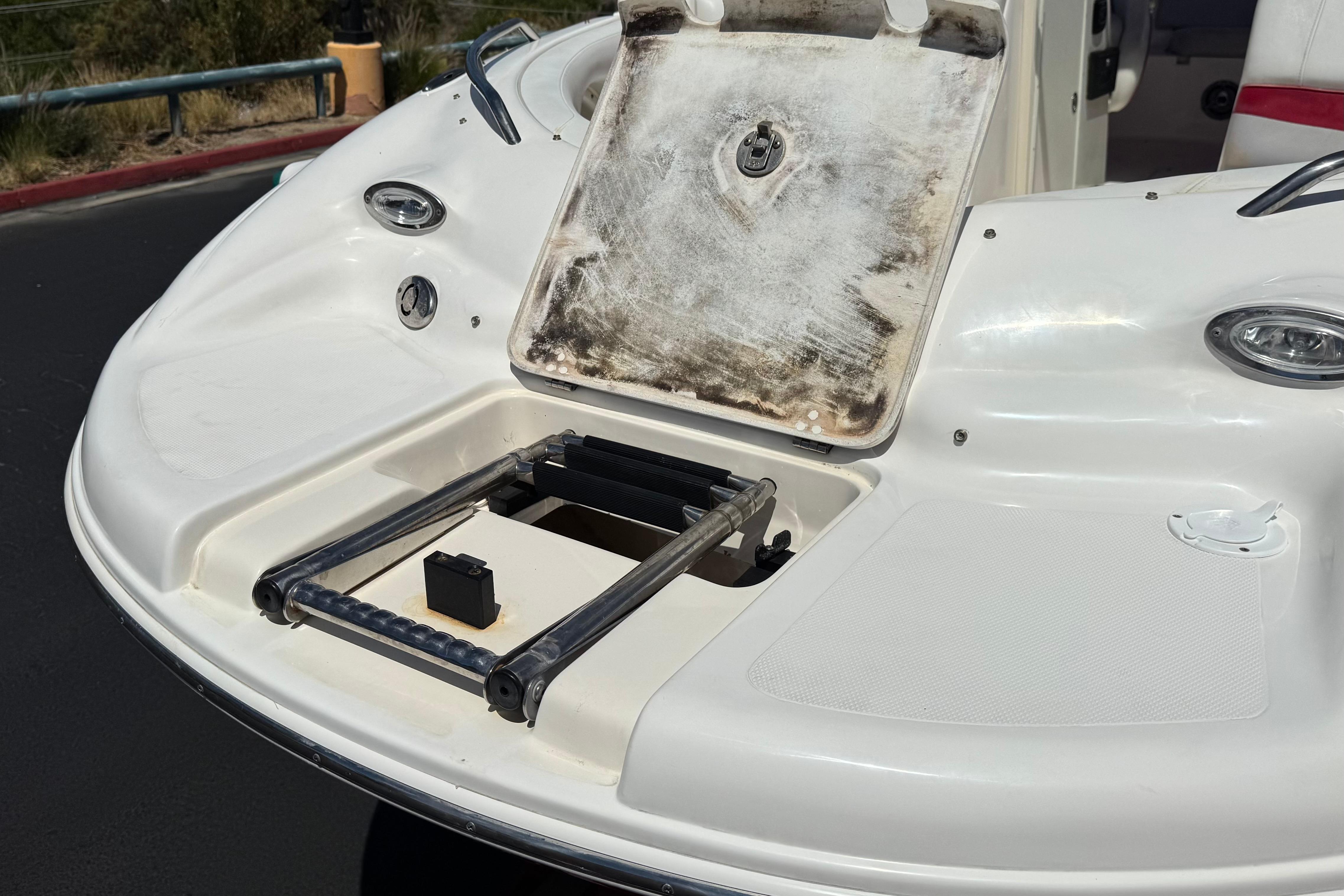 Rear view of a 2010 Bryant 255 boat with a foldable swim ladder.