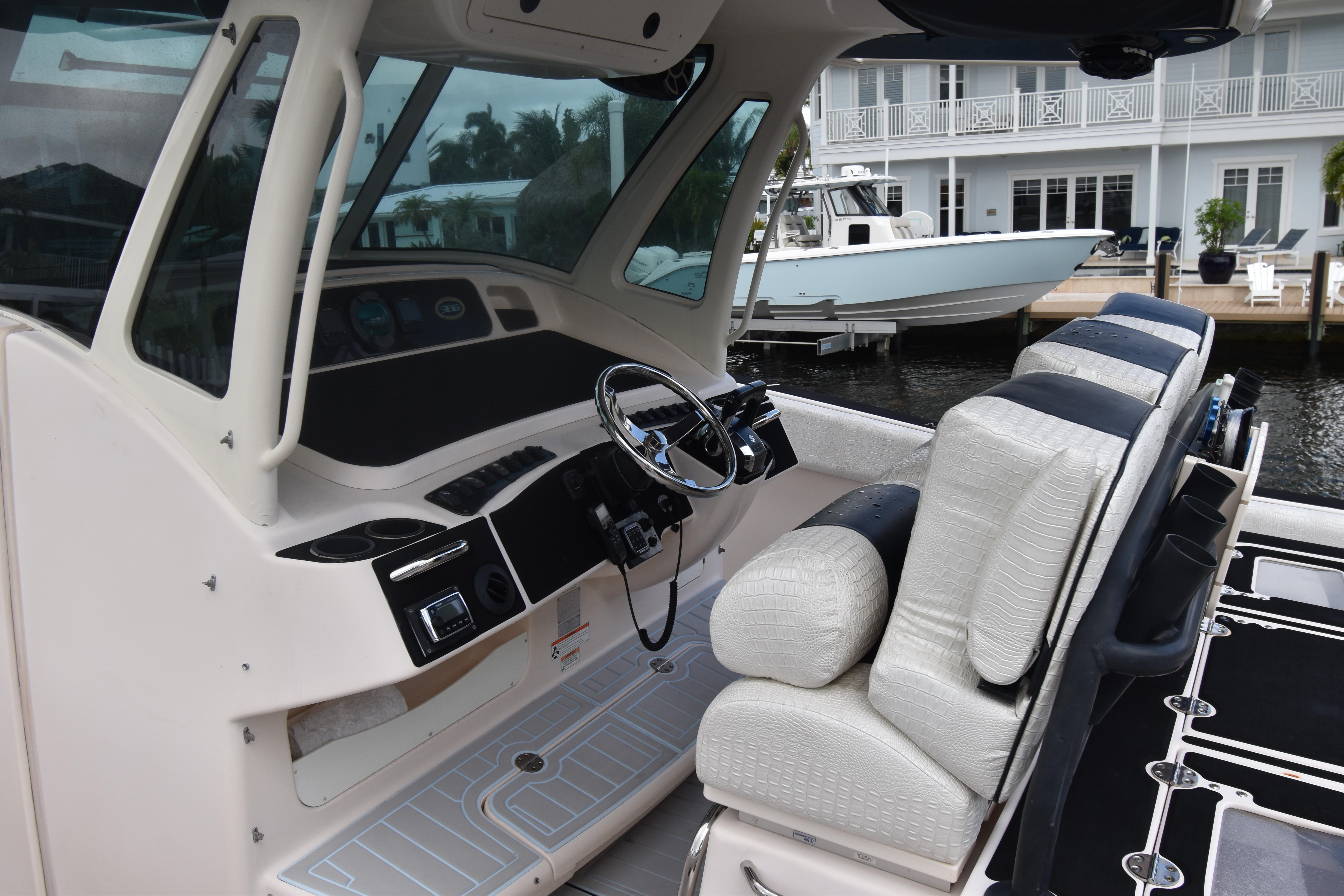 2010 Grady-White Canyon 366 boat interior with helm and seating, docked near waterfront homes.