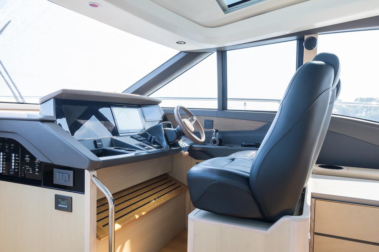 Luxurious helm of a 2019 Princess V60 yacht with modern controls and leather seating.