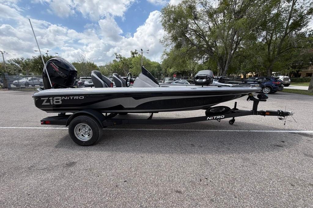 2026 Nitro Z18 boat on trailer in parking lot, under cloudy sky.