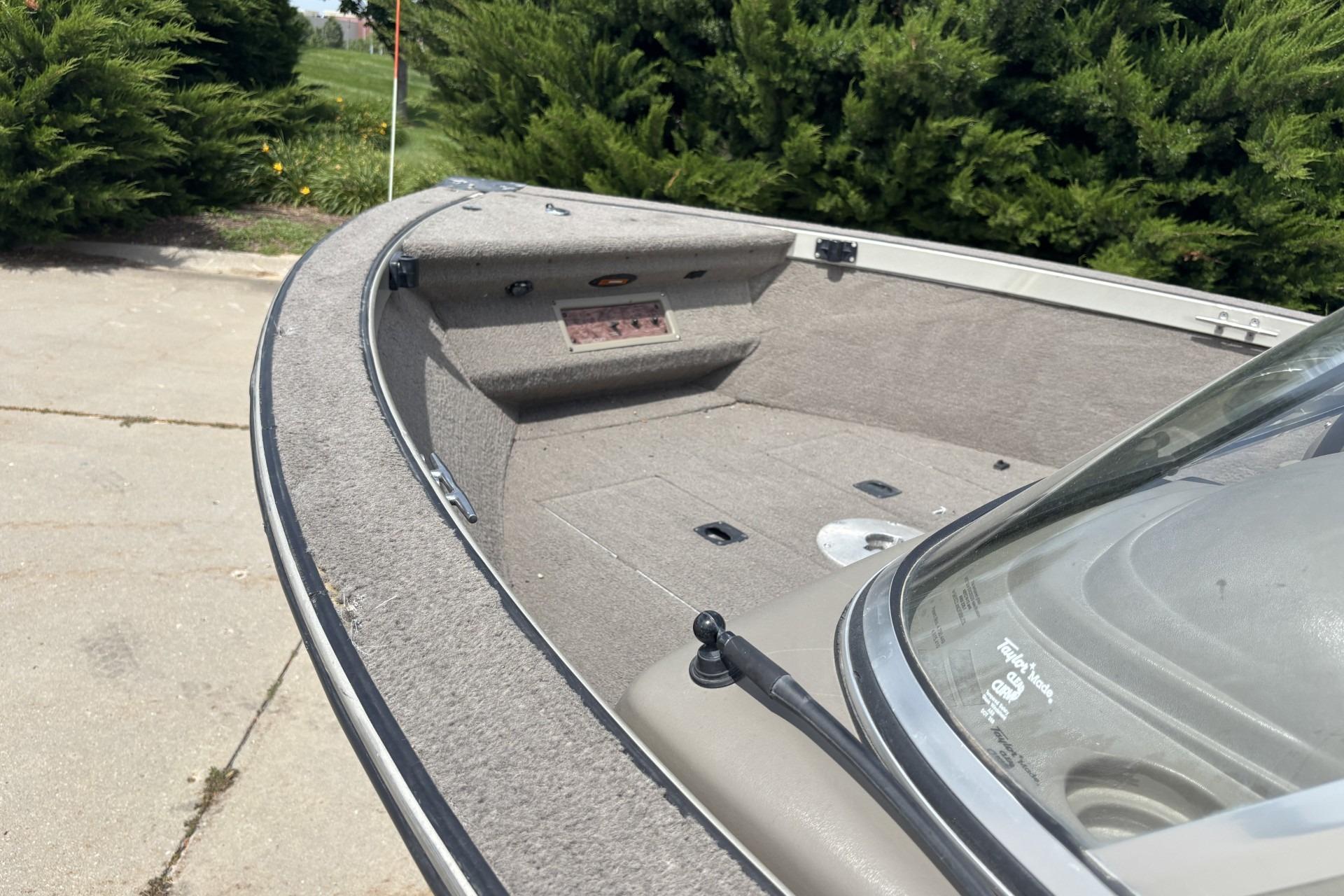1999 Tracker Targa 18 boat interior with carpeted deck and windshield, parked outdoors.