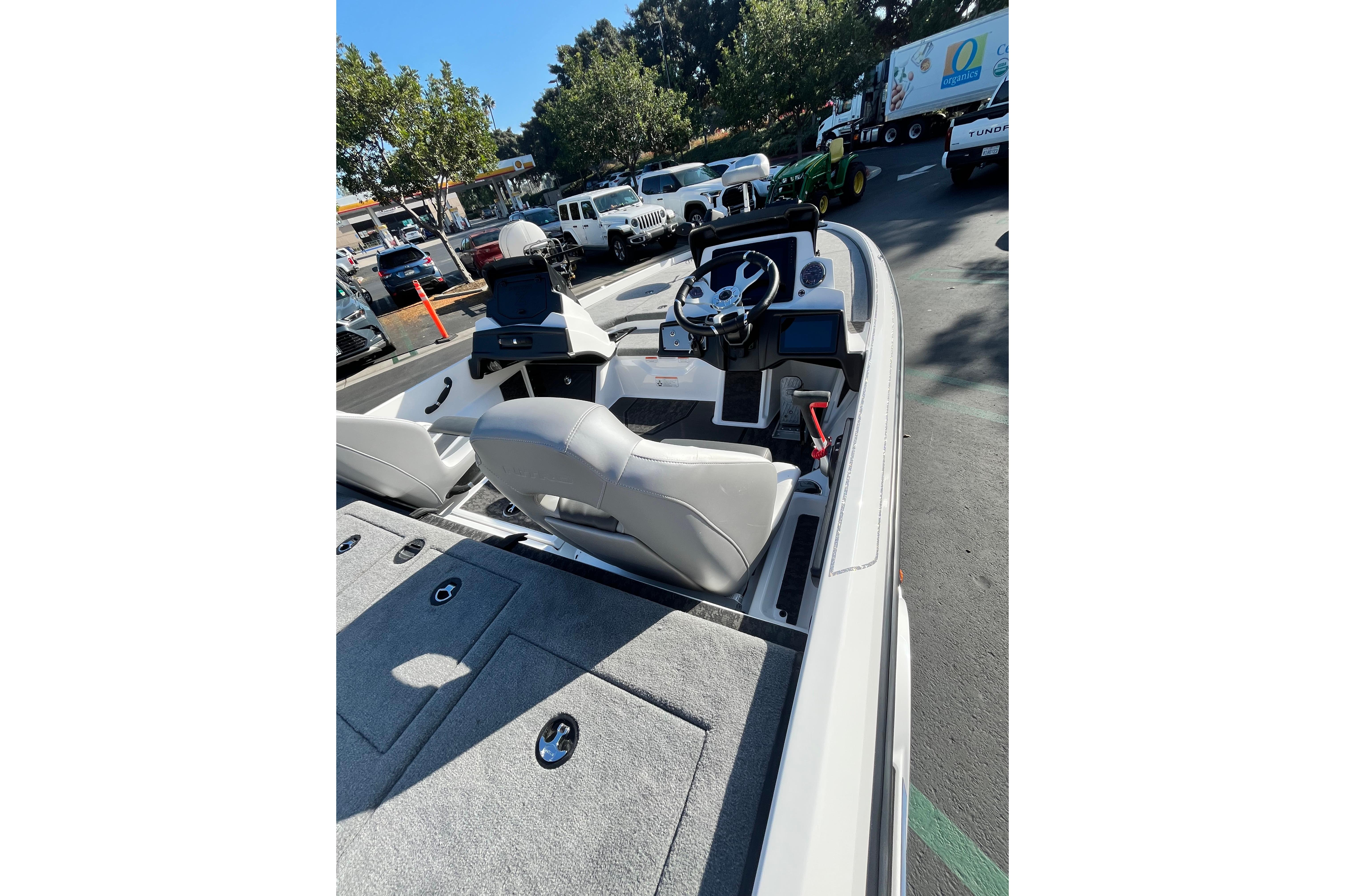 2026 Nitro Z21 XL Pro boat interior with steering wheel and seating in a parking lot.