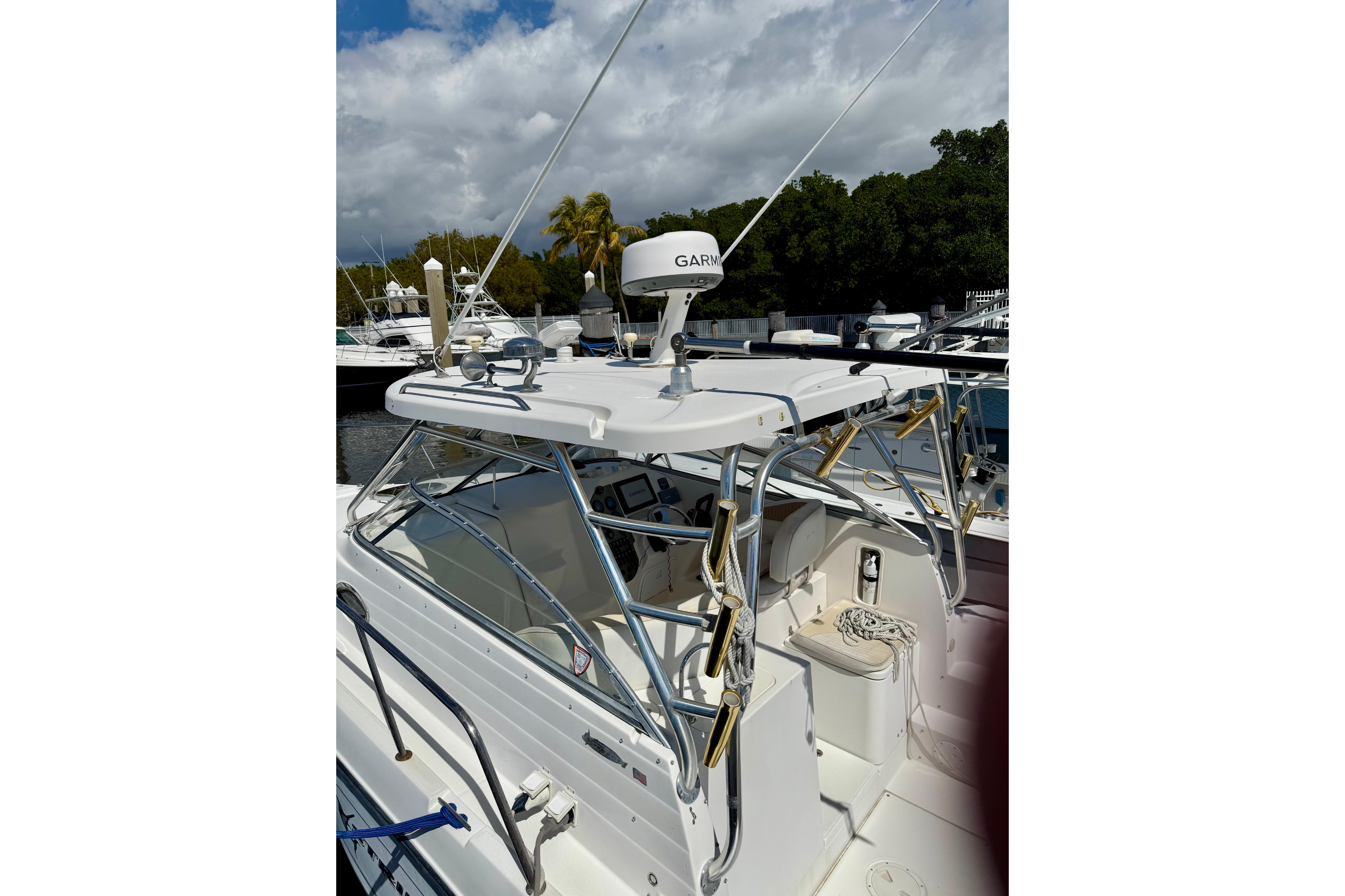 2006 Seaswirl Striper 2901 Walkaround O/B boat with Garmin radar, docked under cloudy sky.