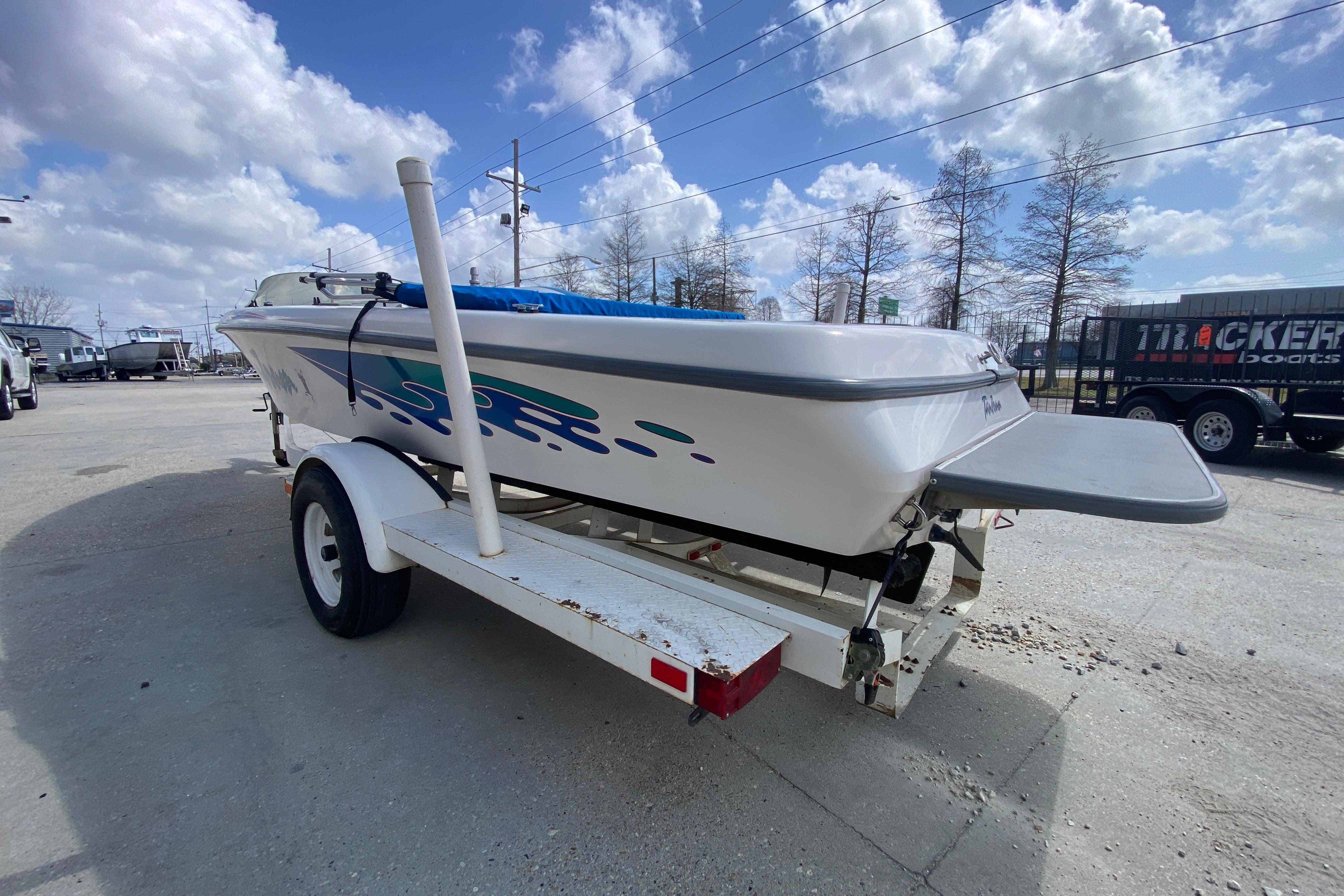 1997 Malibu Tantrum boat on trailer under a partly cloudy sky.
