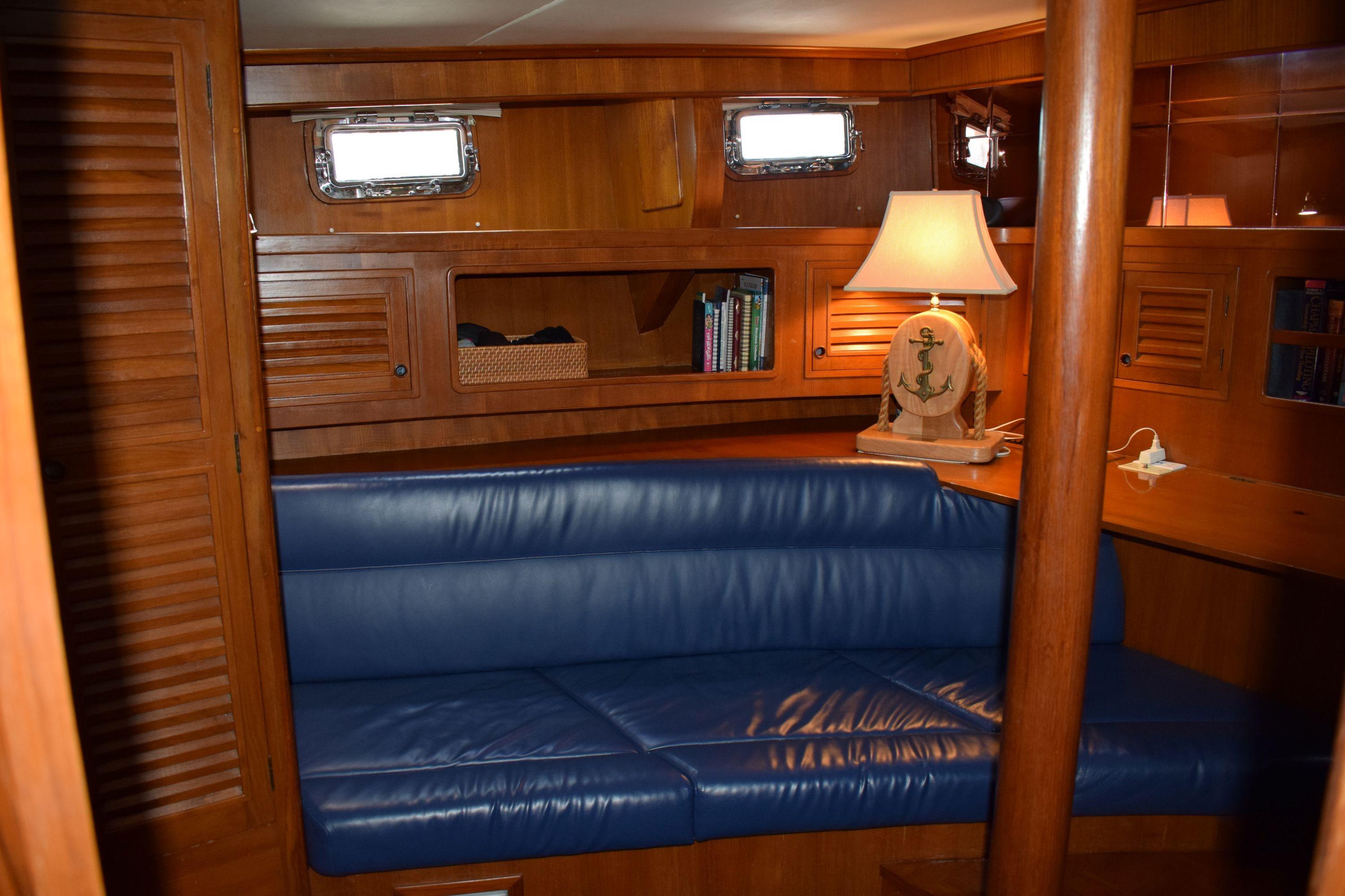 Interior of 1980 Cheoy Lee 52 Motorsailer with blue seating and nautical-themed decor.