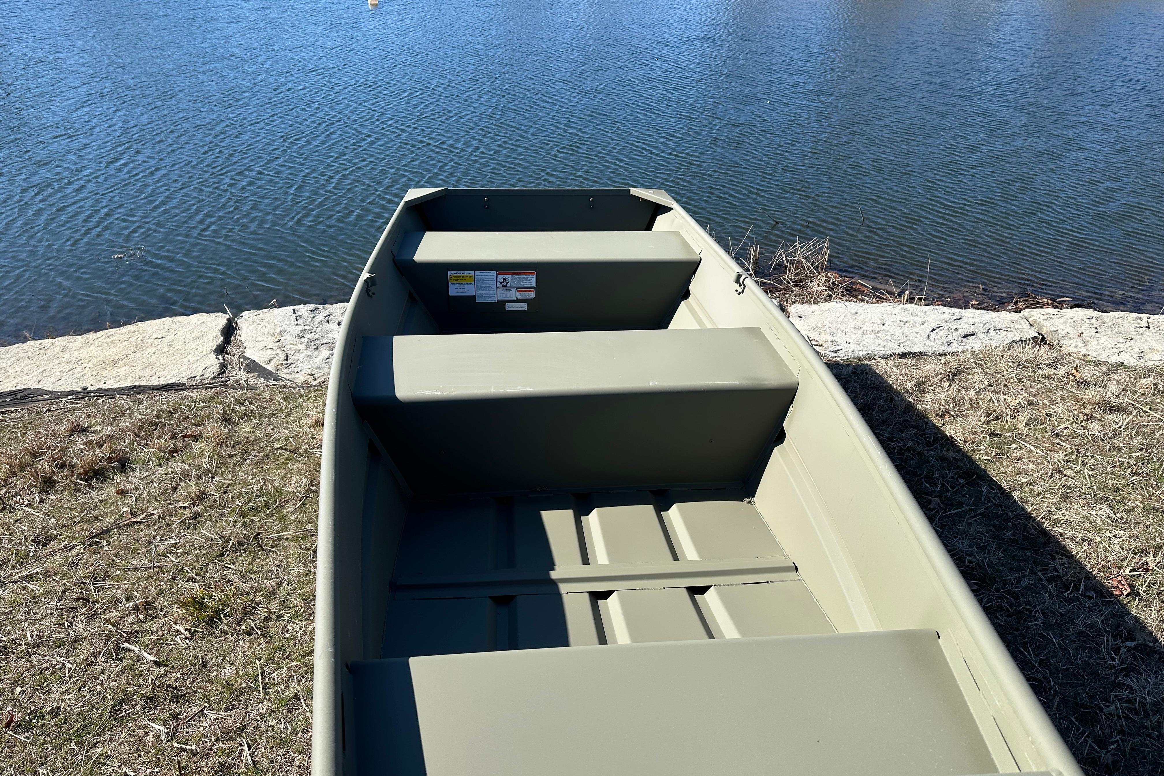 2026 Tracker Grizzly 12 Jon boat by a serene lakeside.