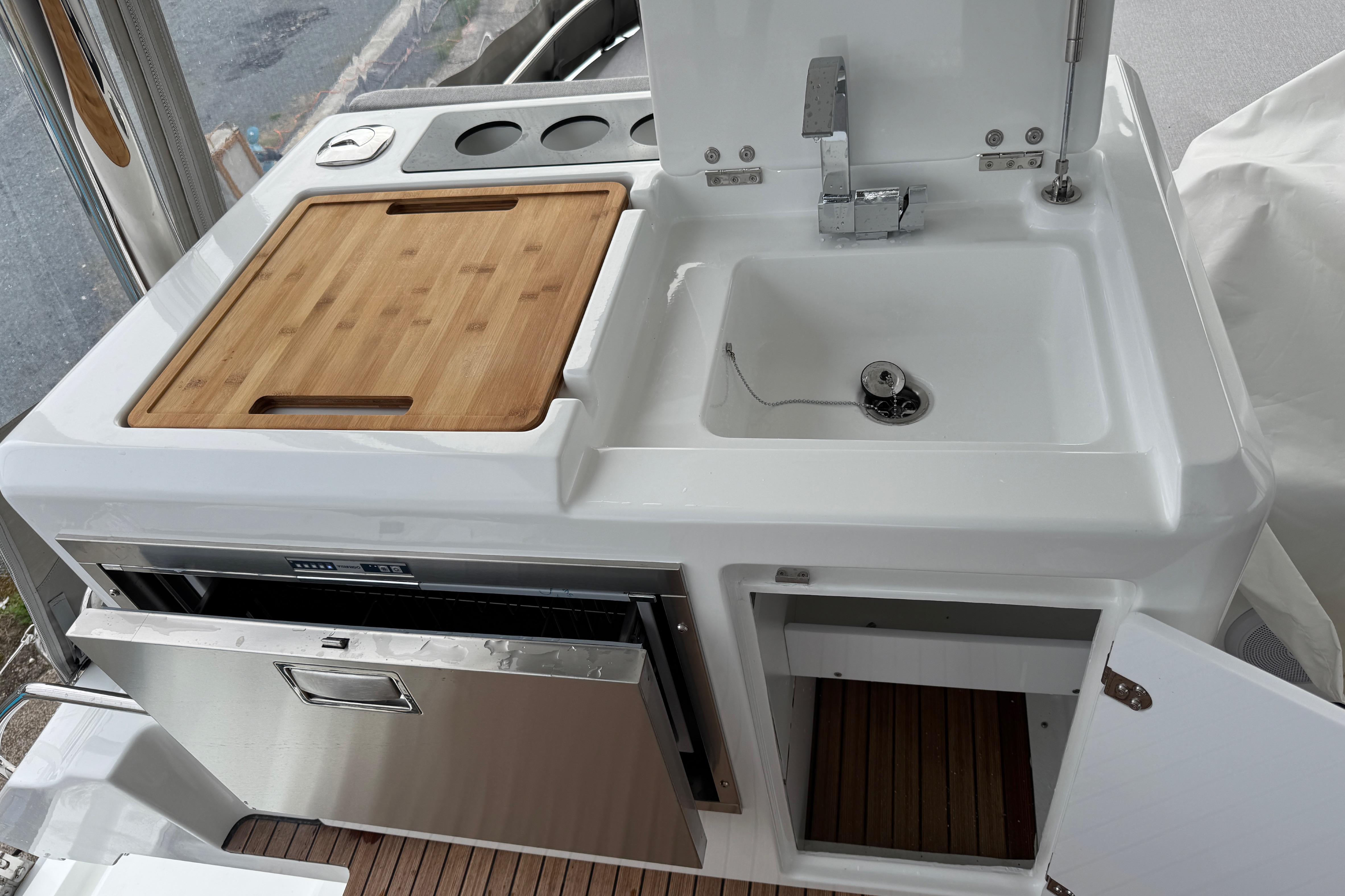 Modern kitchen area on 2026 Lagoon 55 yacht with sink, cutting board, and storage.