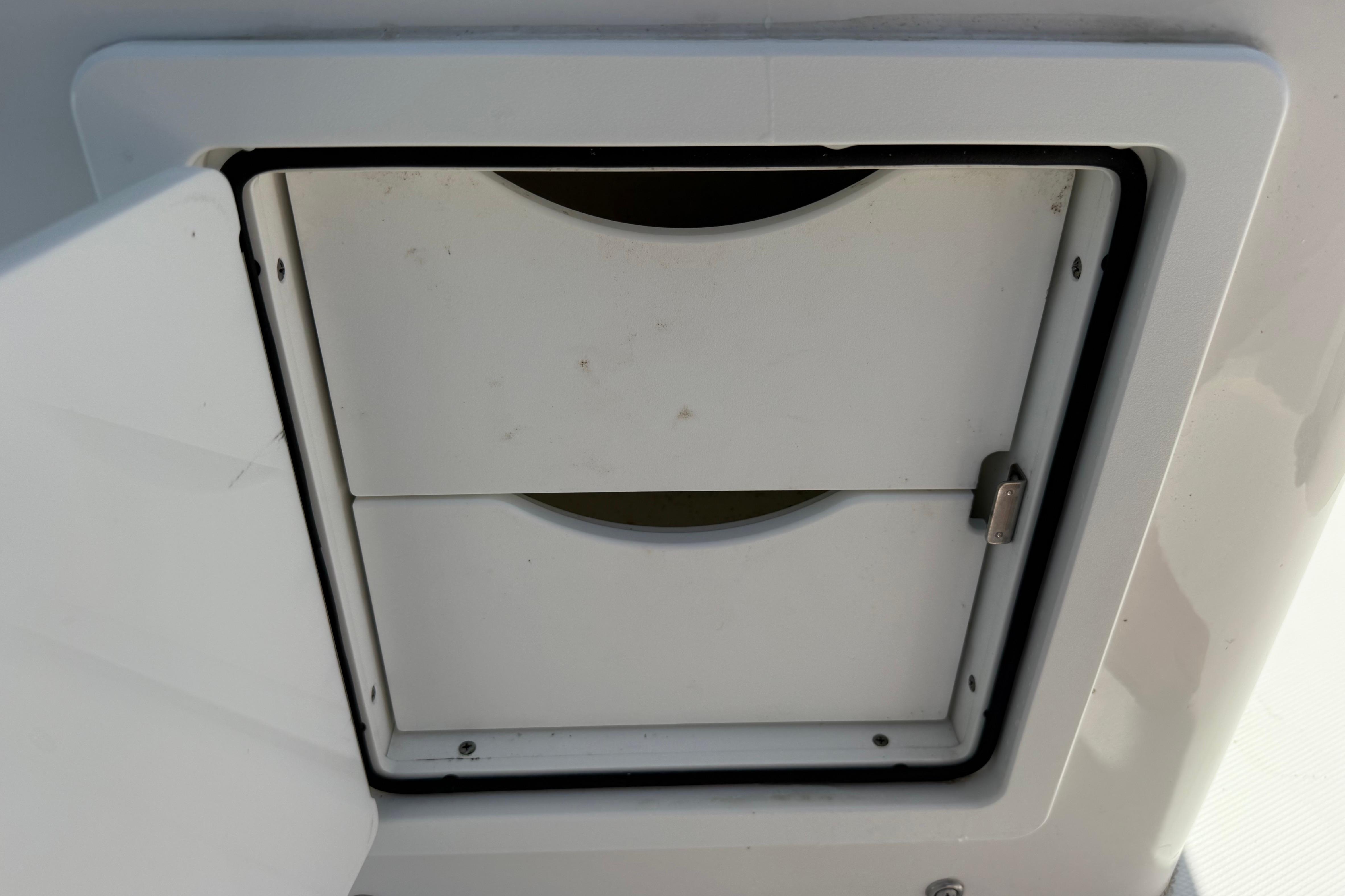 2023 Regulator 26XO boat compartment with secure latch and white finish.