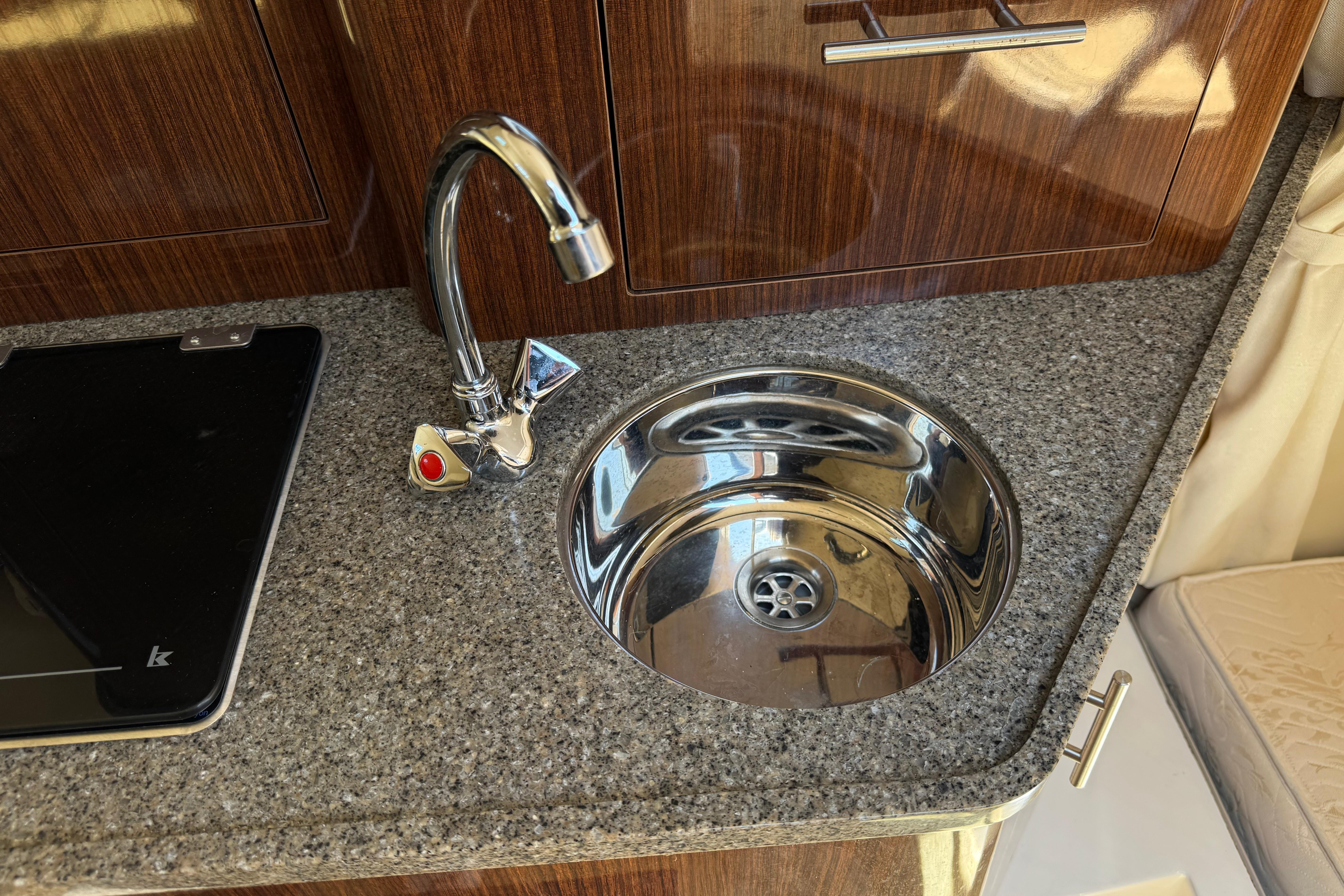 2013 Regal 28 Express boat kitchen sink with chrome faucet and granite countertop.
