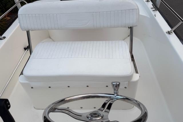 2016 Boston Whaler 150 Montauk boat interior with white seating and steering wheel.