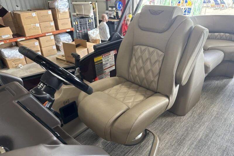 2026 Bennington 24 LXS Quadbench boat interior with luxurious captain's chair and steering wheel.