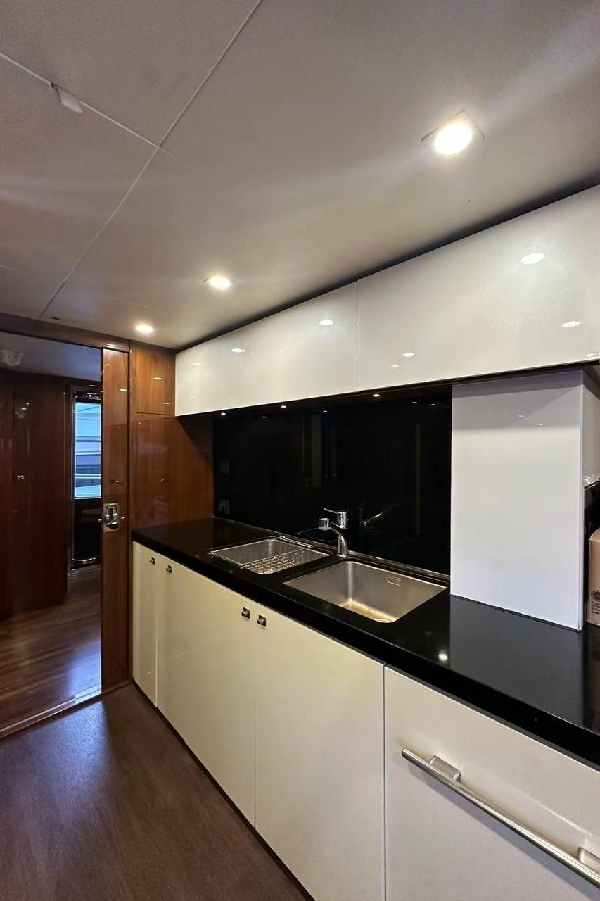 Modern kitchen interior on 2013 Princess M Class 32M yacht, featuring sleek cabinetry and lighting.