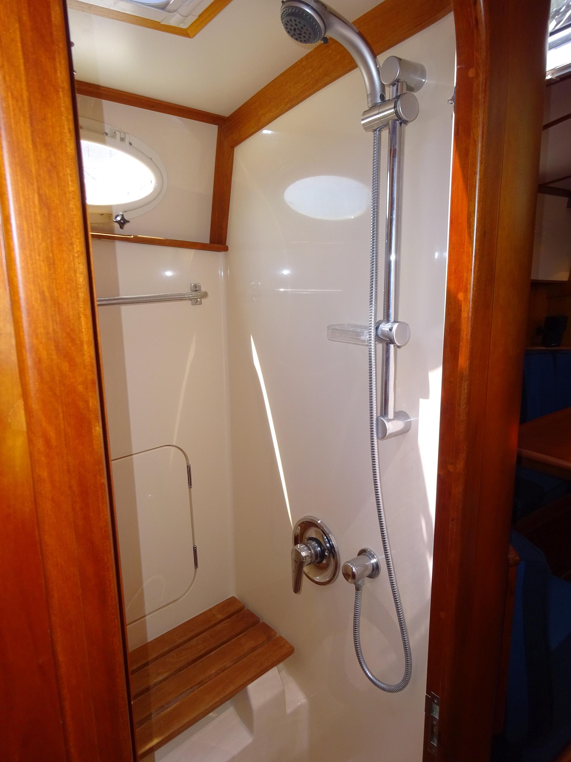 Shower area in 2002 Hinckley Talaria 44 FB yacht with wooden accents and modern fixtures.