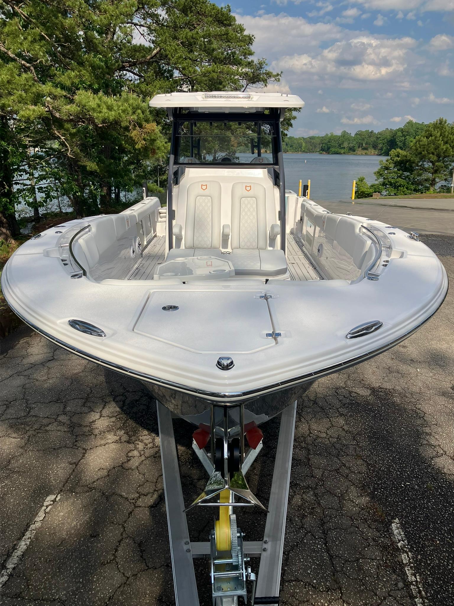 2025 Sea Fox 328 Commander boat on trailer, surrounded by trees and lake view.