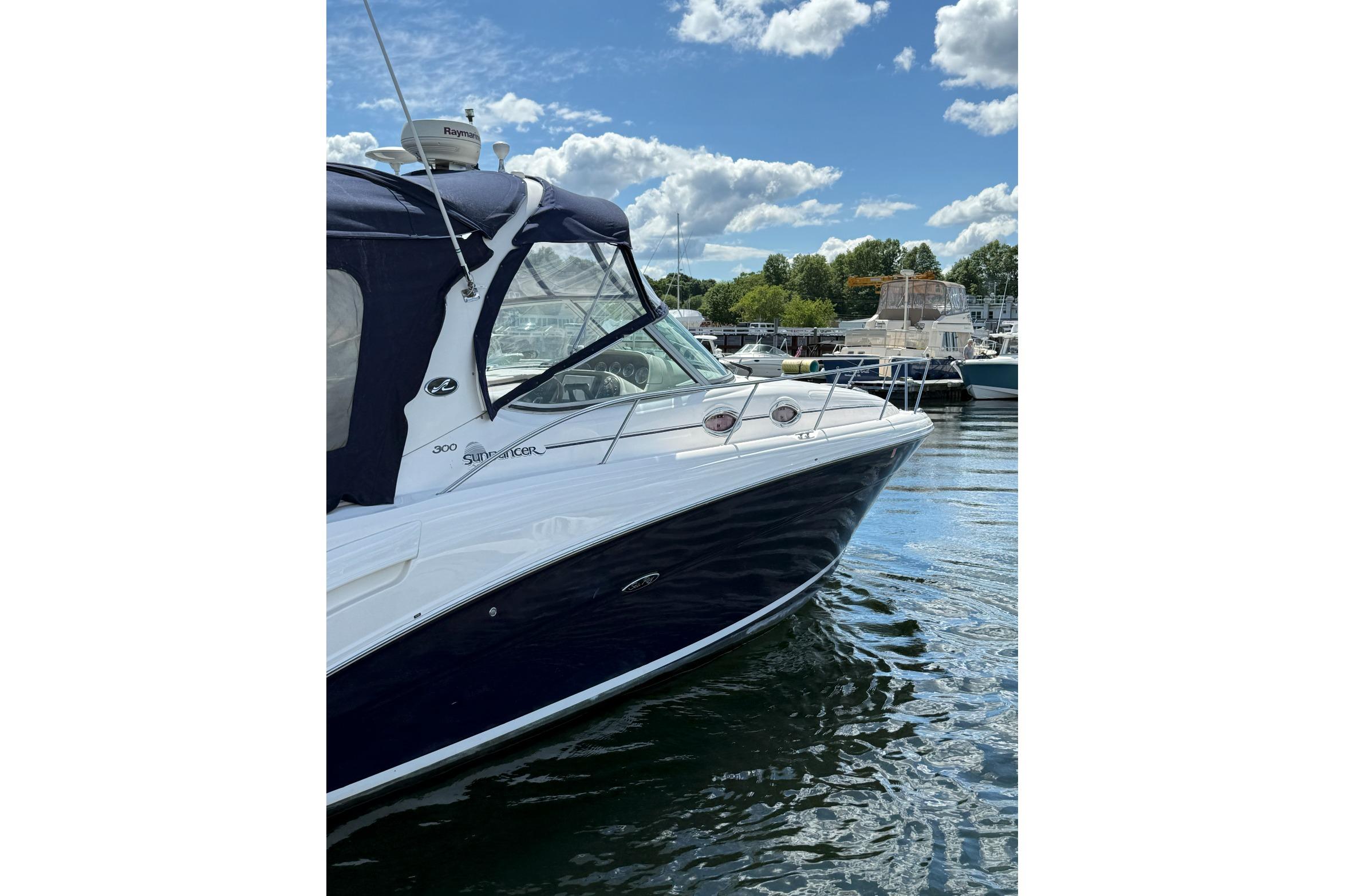 2006 Sea Ray 300 Sundancer boat docked on a sunny day with blue skies.