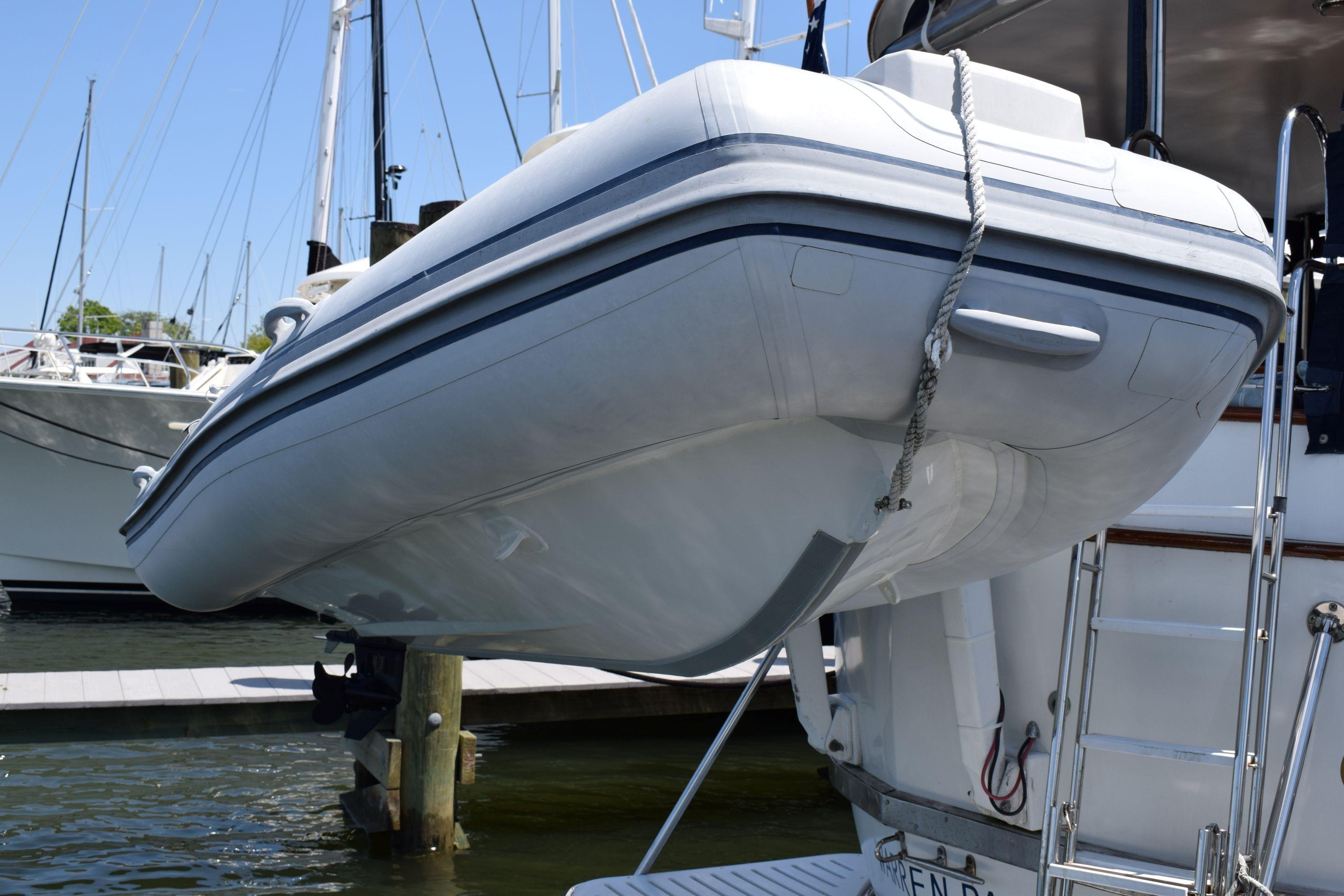 Inflatable dinghy on a 1980 Cheoy Lee 52 Motorsailer, docked at a marina.
