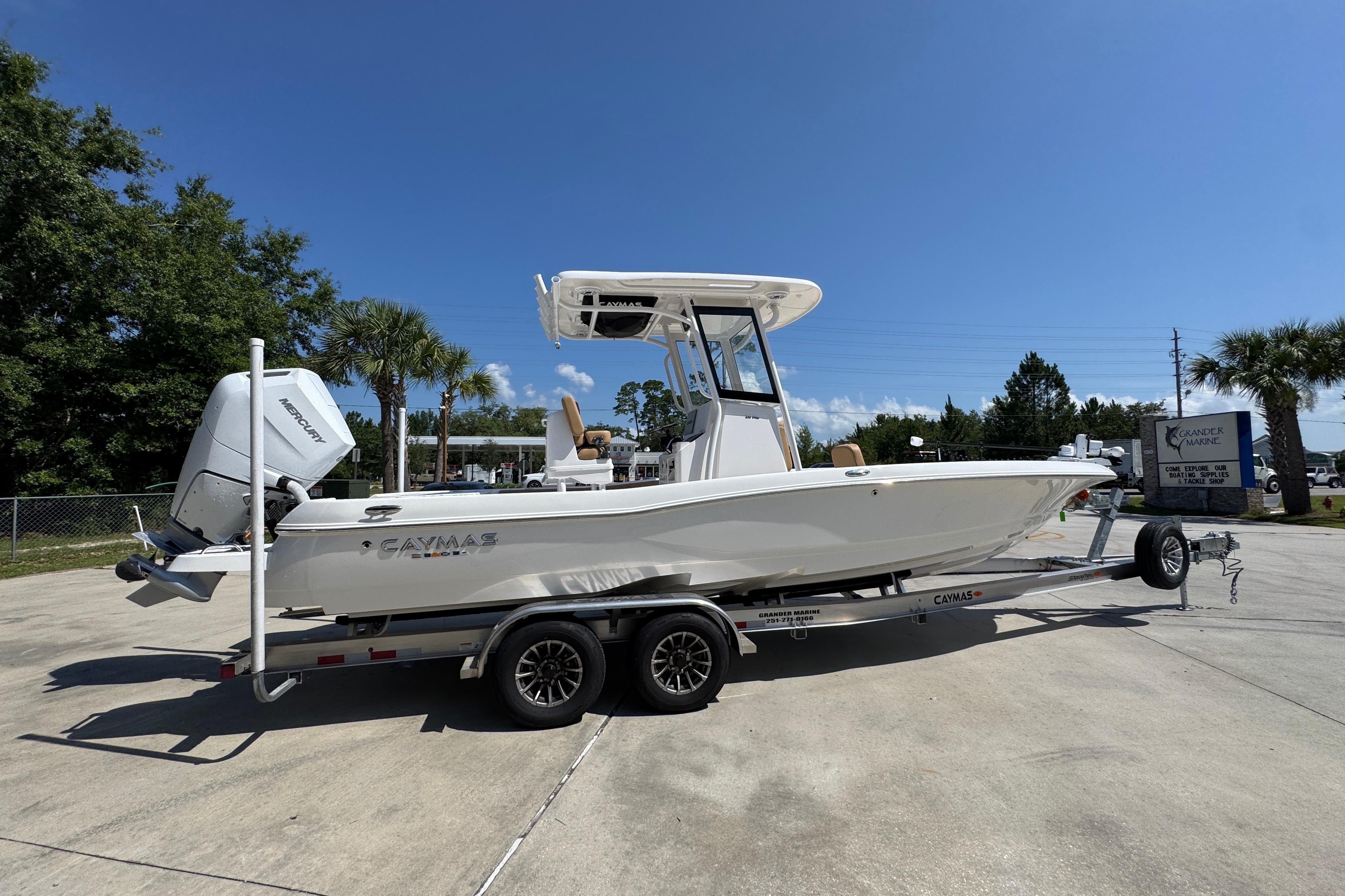 2027 Caymas 26 HB boat on trailer, parked outdoors under clear blue sky.