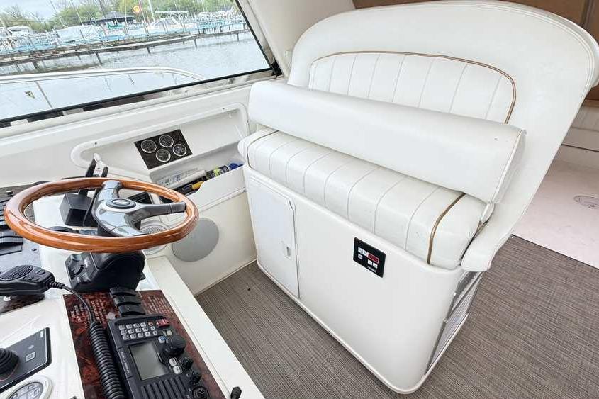 Interior of 1998 Sea Ray 370 Express Cruiser with helm and white seating.