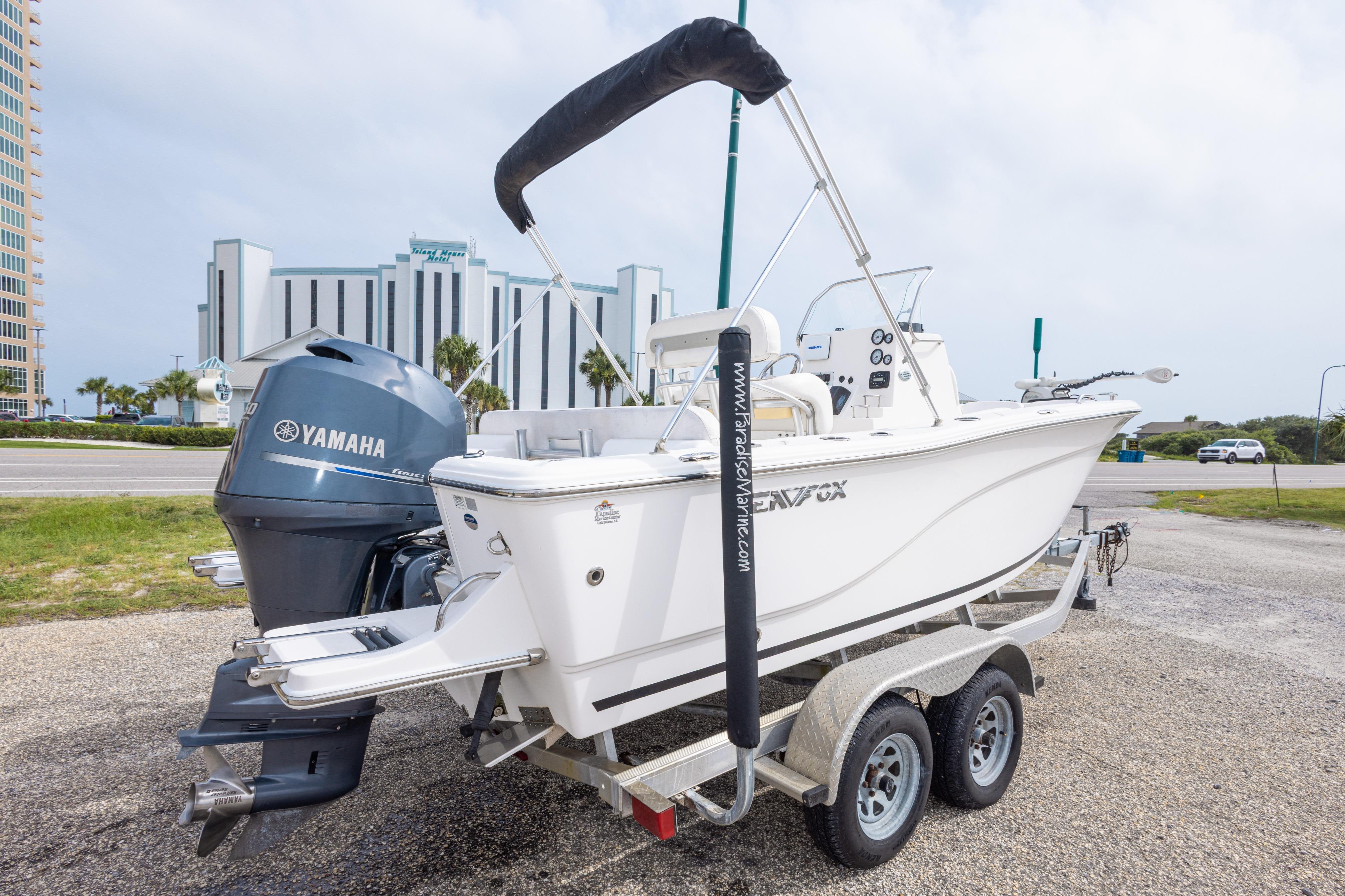2014 Sea Fox 209 Commander boat on trailer with Yamaha engine, parked near a building.