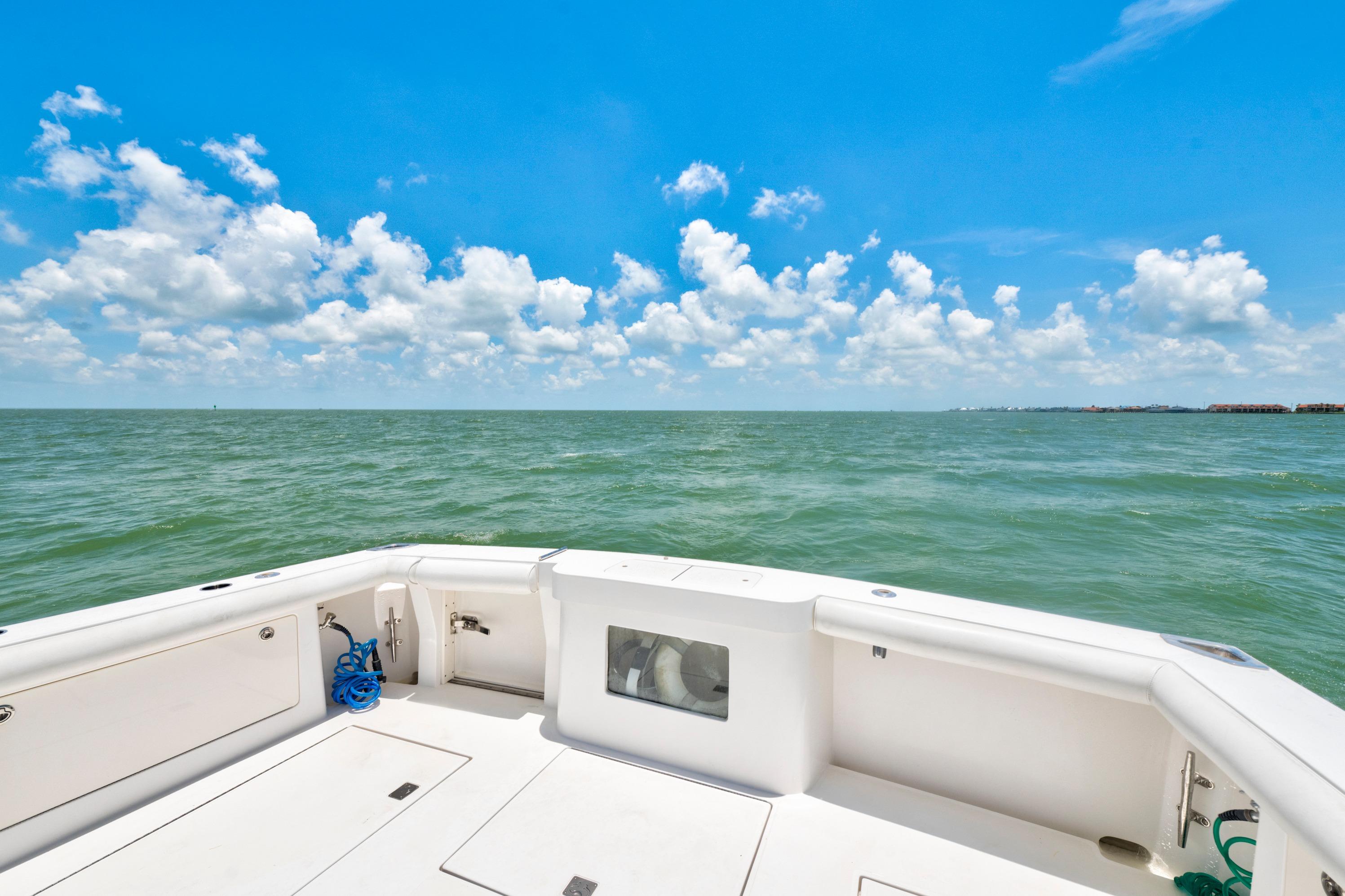 2010 Cabo 45 Express boat deck overlooking calm ocean under blue sky.