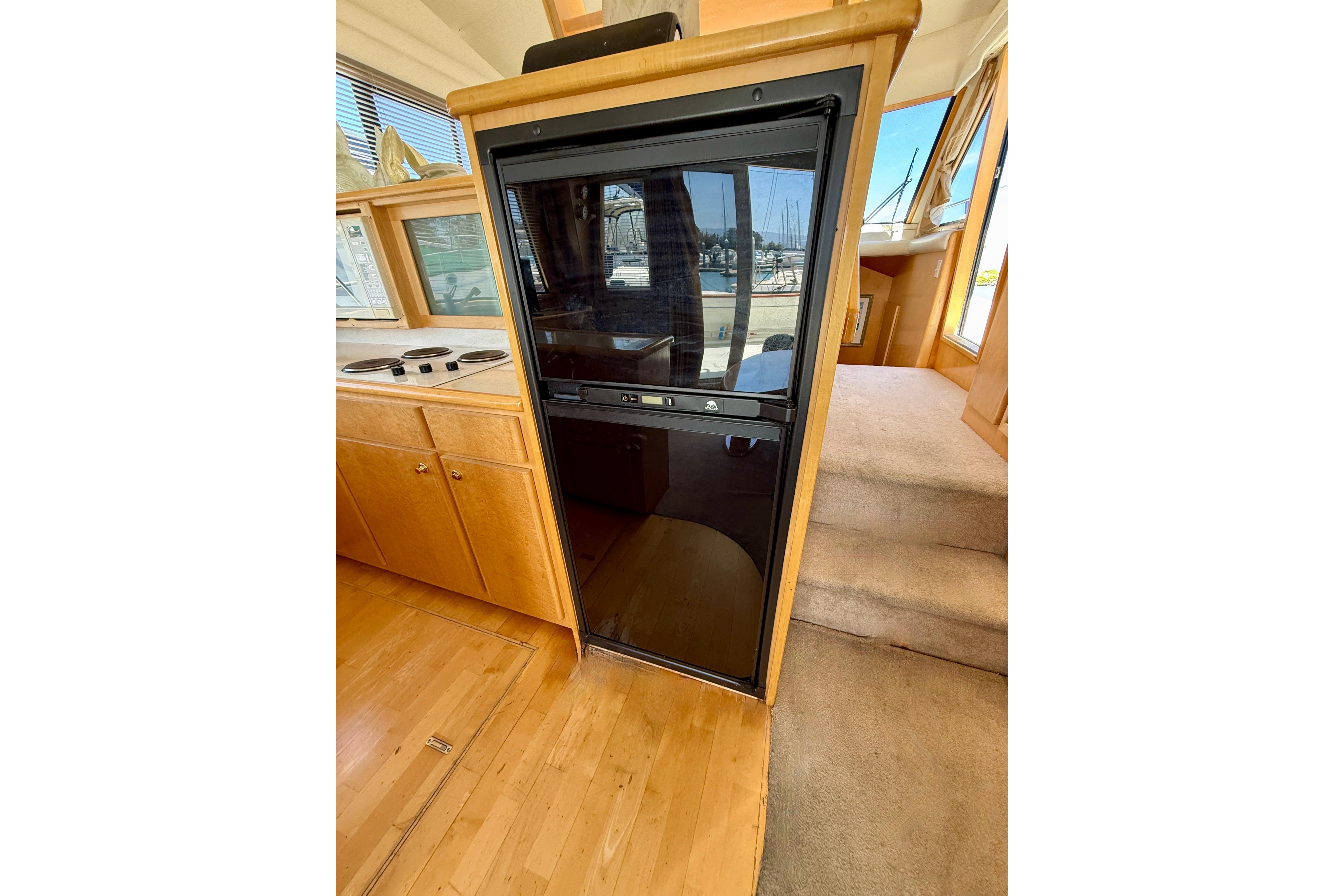 Interior of 1997 Navigator Pilothouse yacht with wooden cabinetry and carpeted steps.