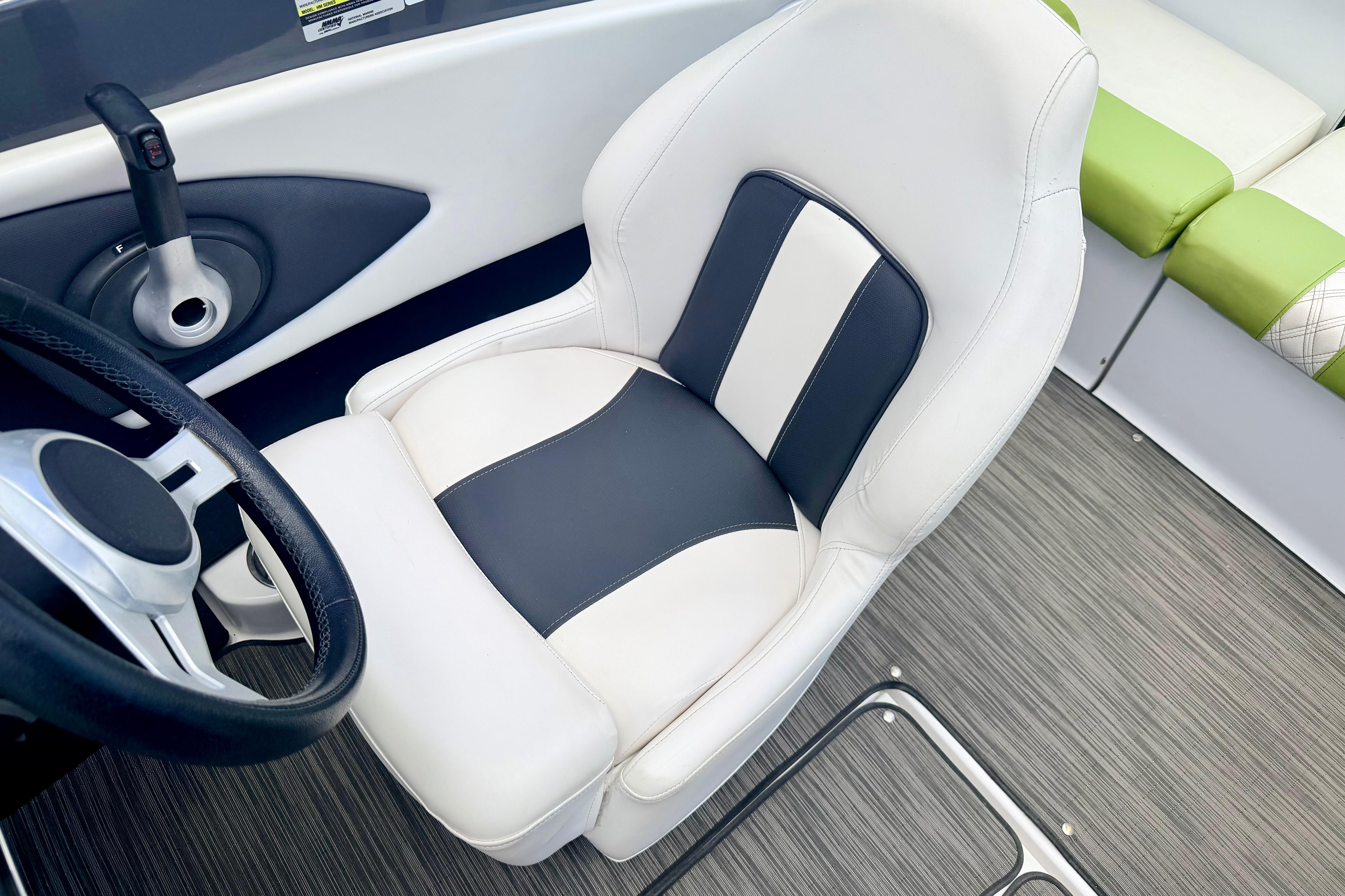 2018 Glastron GT 185 boat interior with white and black captain's seat and steering wheel.