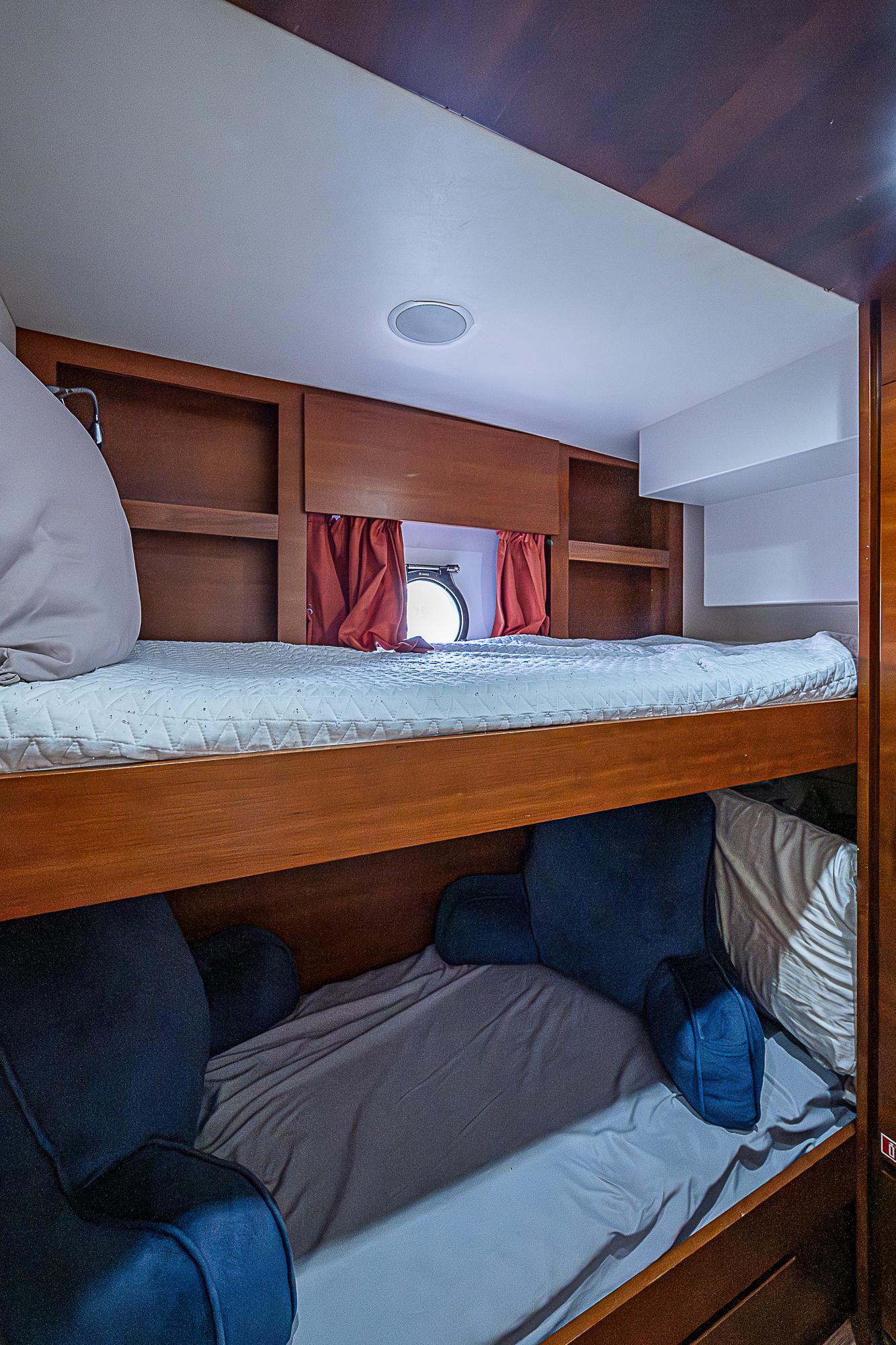 Bunk beds in 2011 Azimut 82 yacht cabin with wooden finish and porthole.