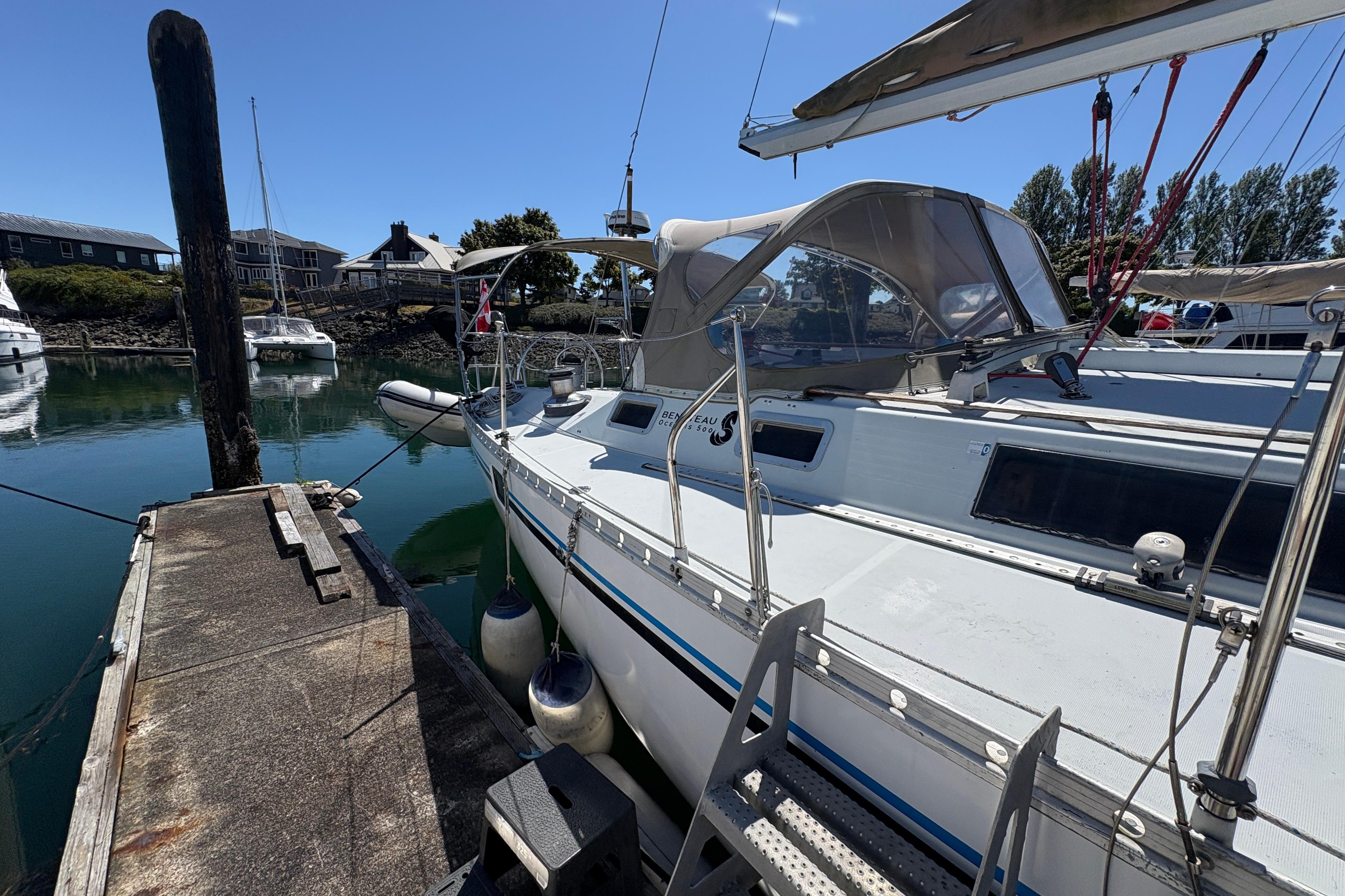 1990 Beneteau Oceanis 500 sailboat docked at a marina on a sunny day.