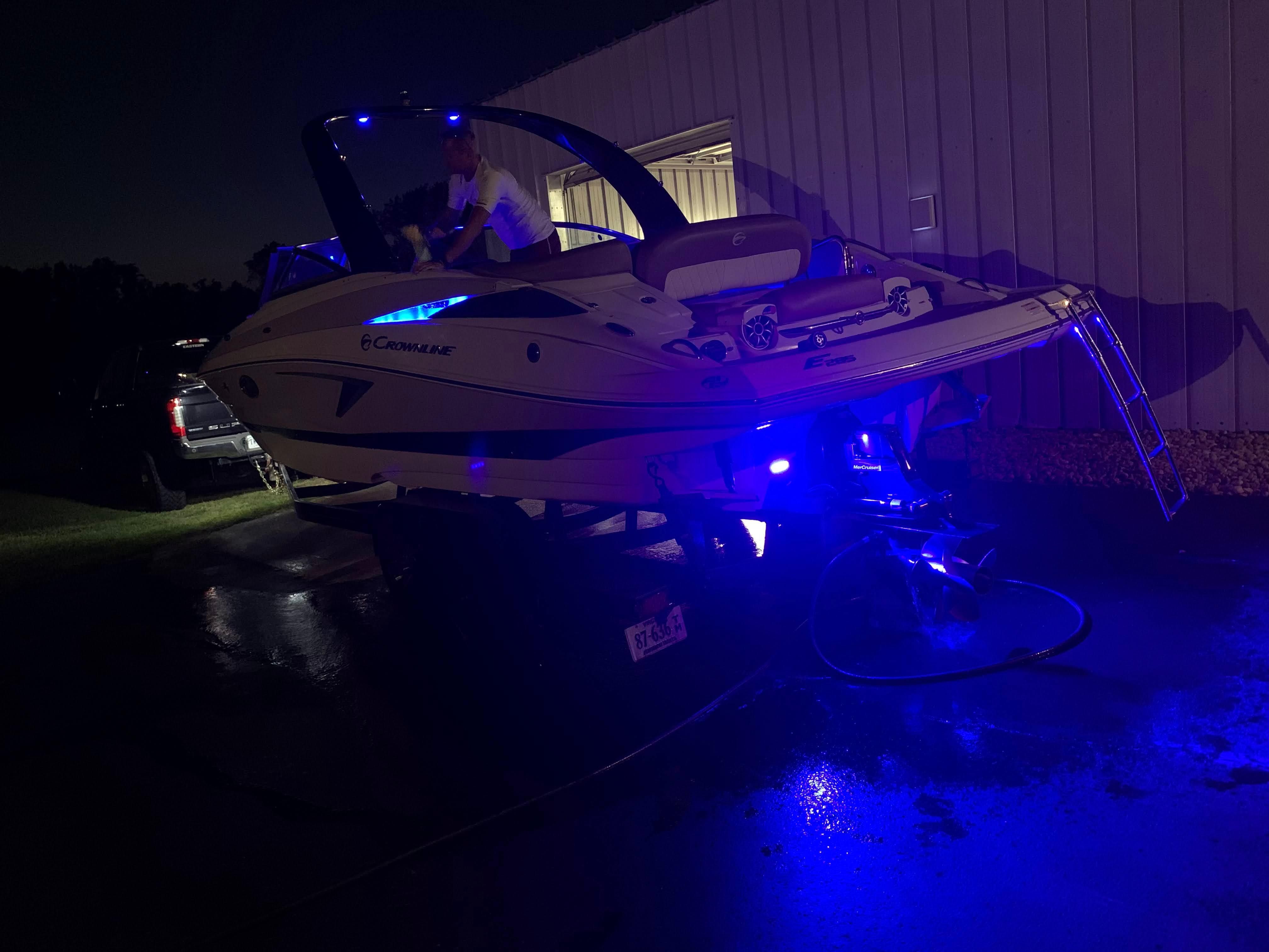 2019 Crownline E 285 boat with blue lighting, on a trailer at night.