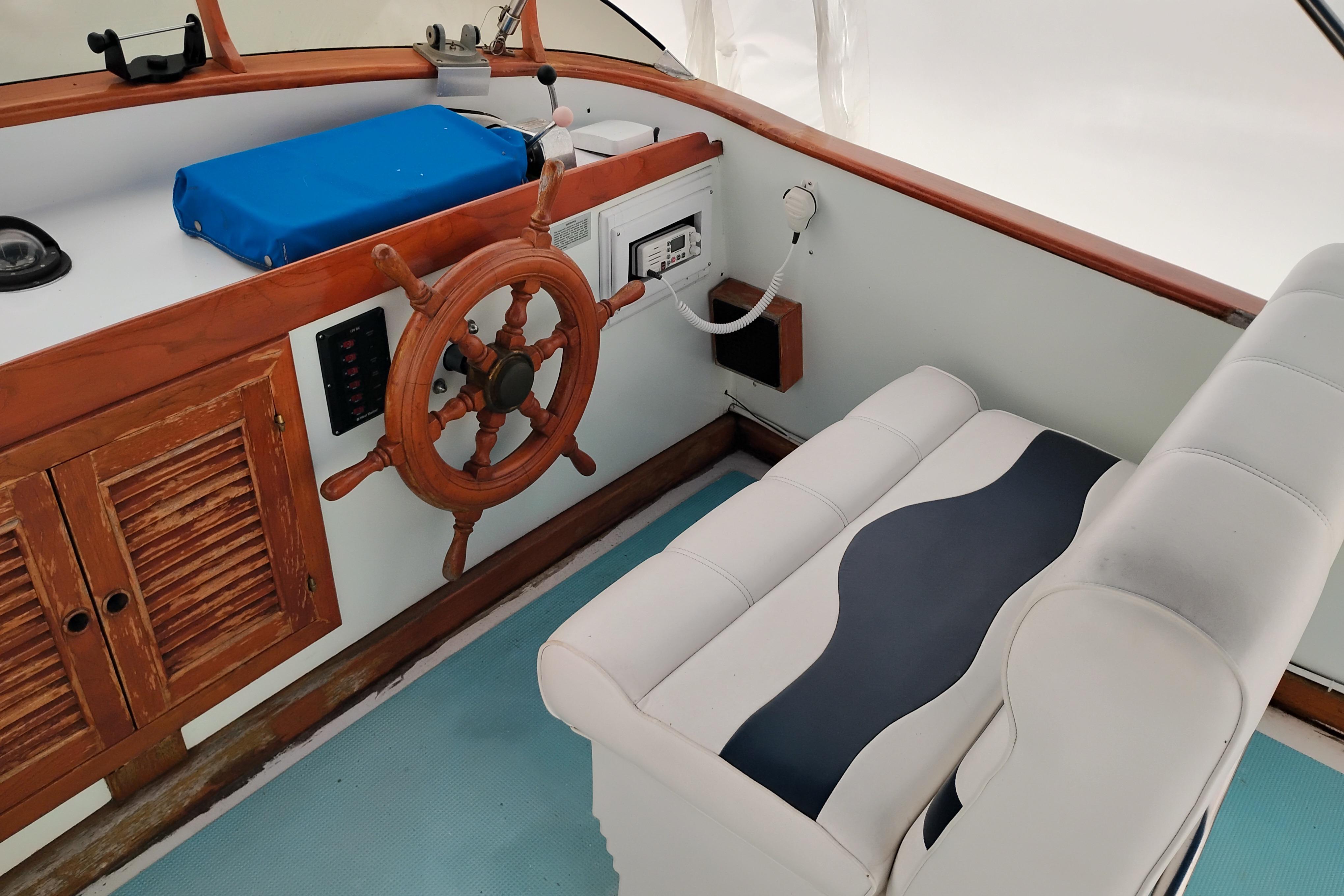 1979 Transpac Eagle 36 Trawler helm with wooden wheel and cushioned seating.