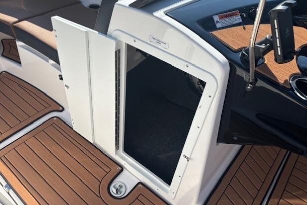 2026 Yamaha Boats 222SE interior storage compartment with open hatch and wood-textured flooring.