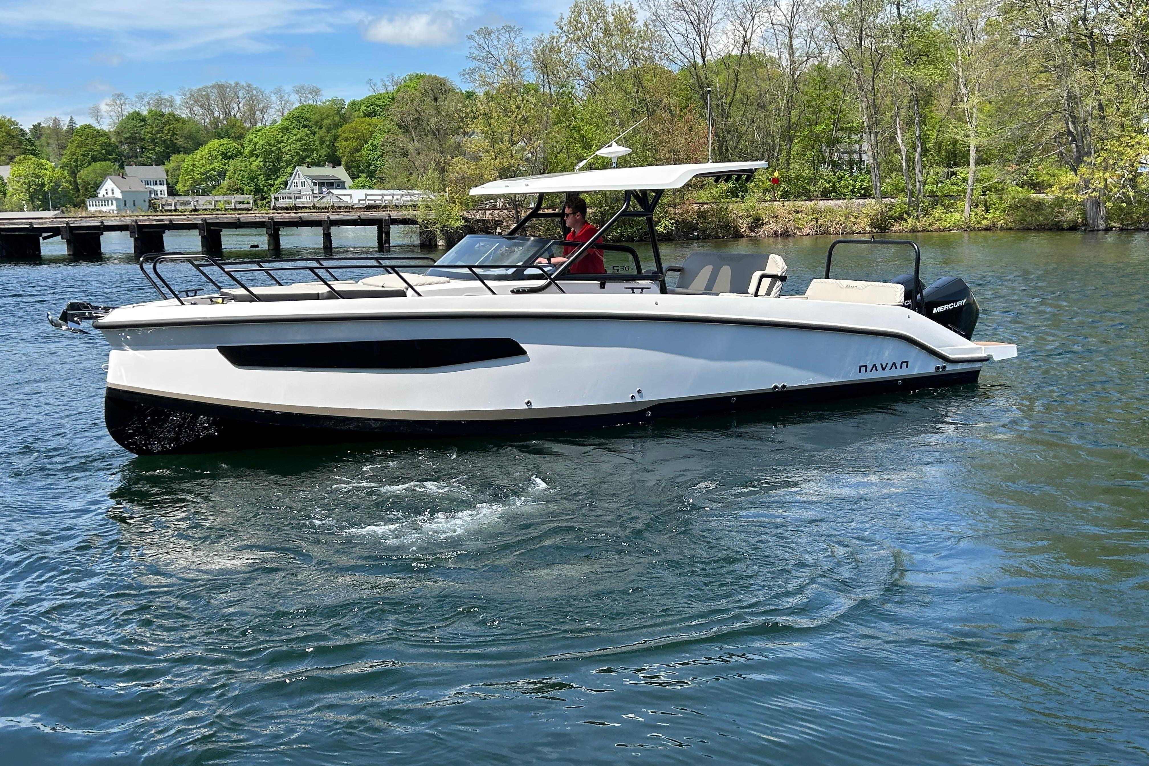 2025 Navan S30 boat cruising on a scenic lake with lush greenery in the background.