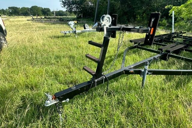 Trailer for 2019 Sun Tracker Party Barge 22 XP3 on grassy field.