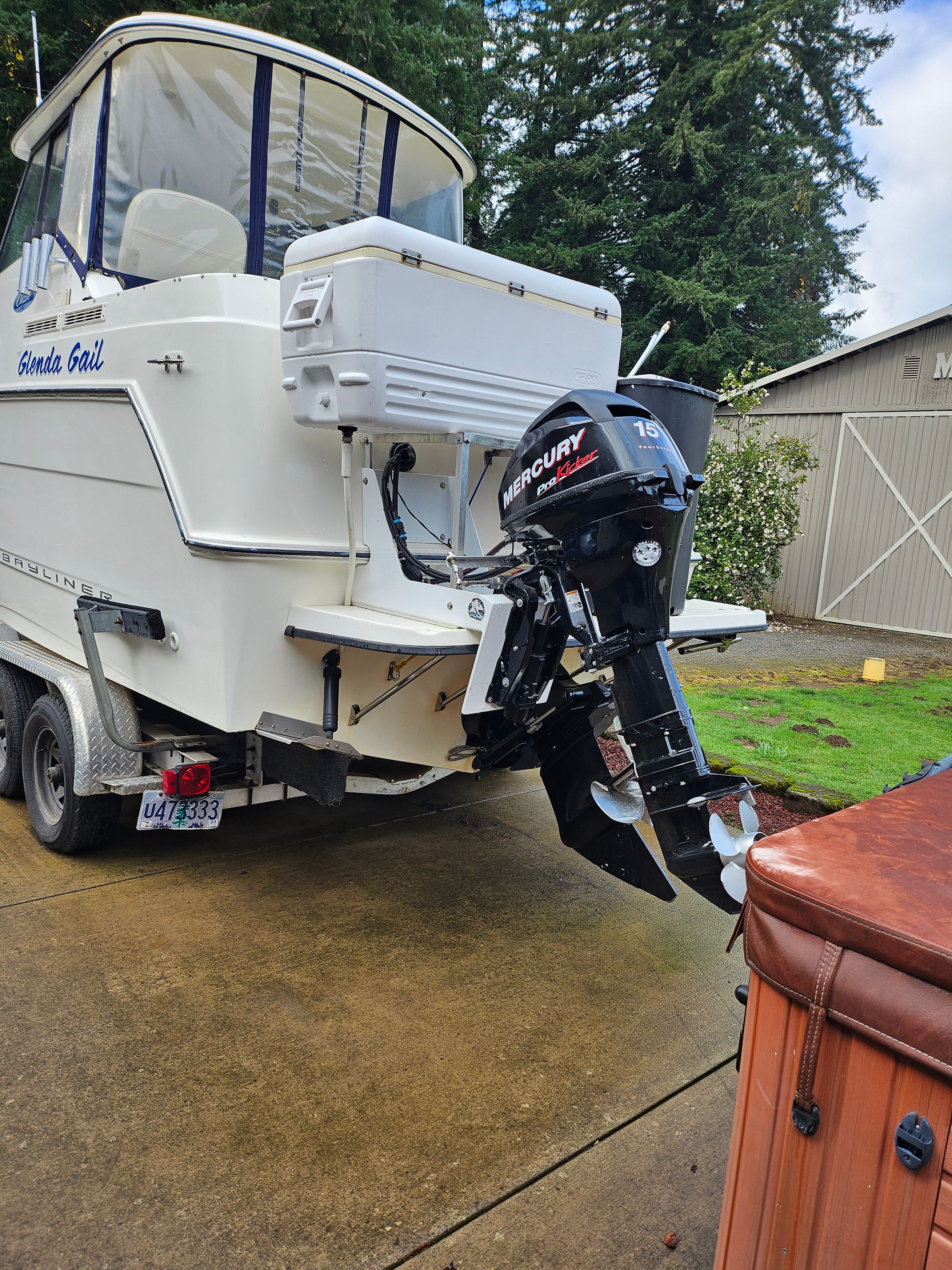 A 2005 Bayliner 242 Ceara on a trailer. A Mercury outboard motor is visible.