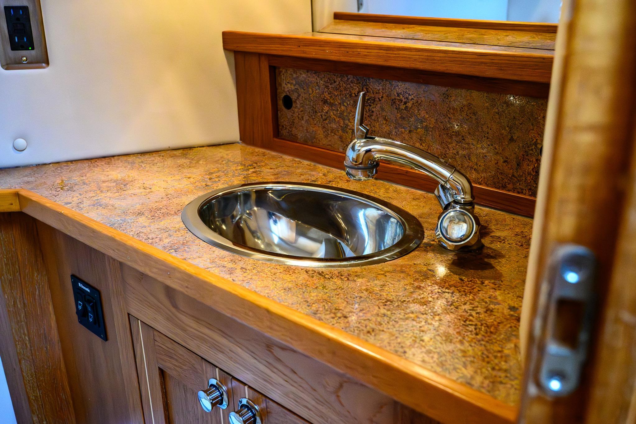 2012 Aspen C90 interior sink with chrome faucet and wood cabinetry.