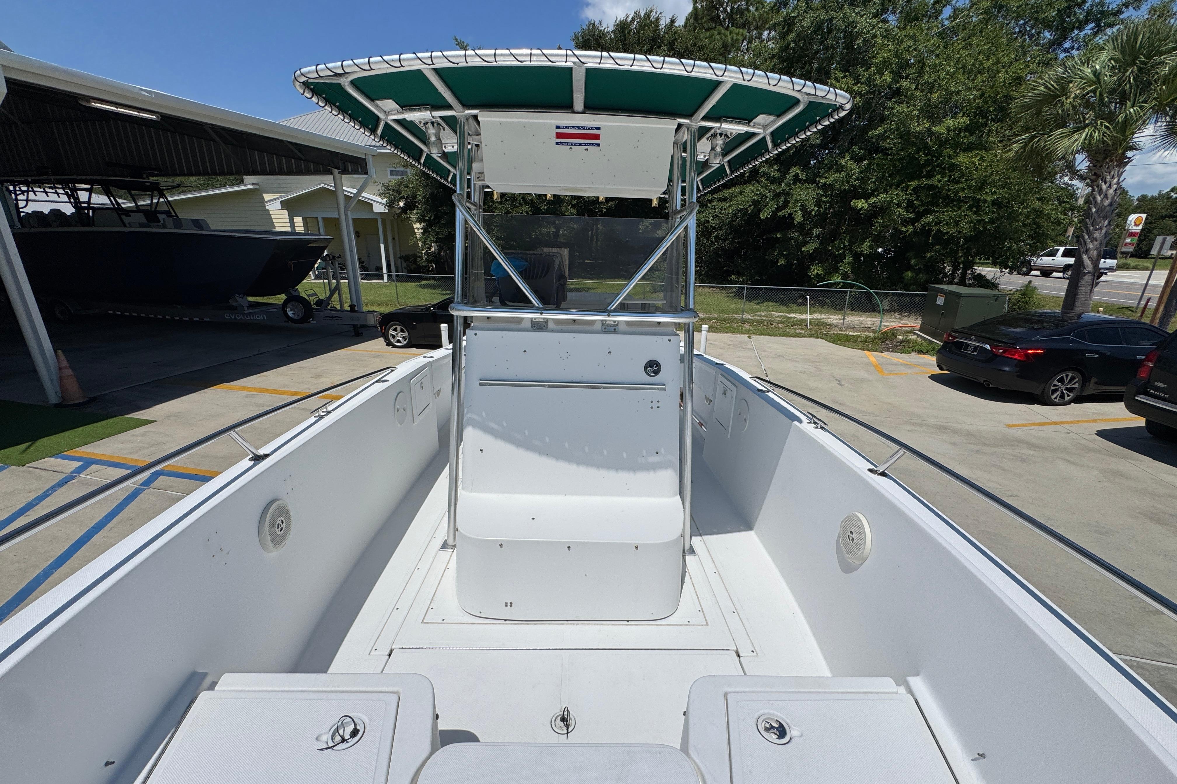 2000 Stamas 250 Tarpon boat with T-top, parked outdoors on a sunny day.