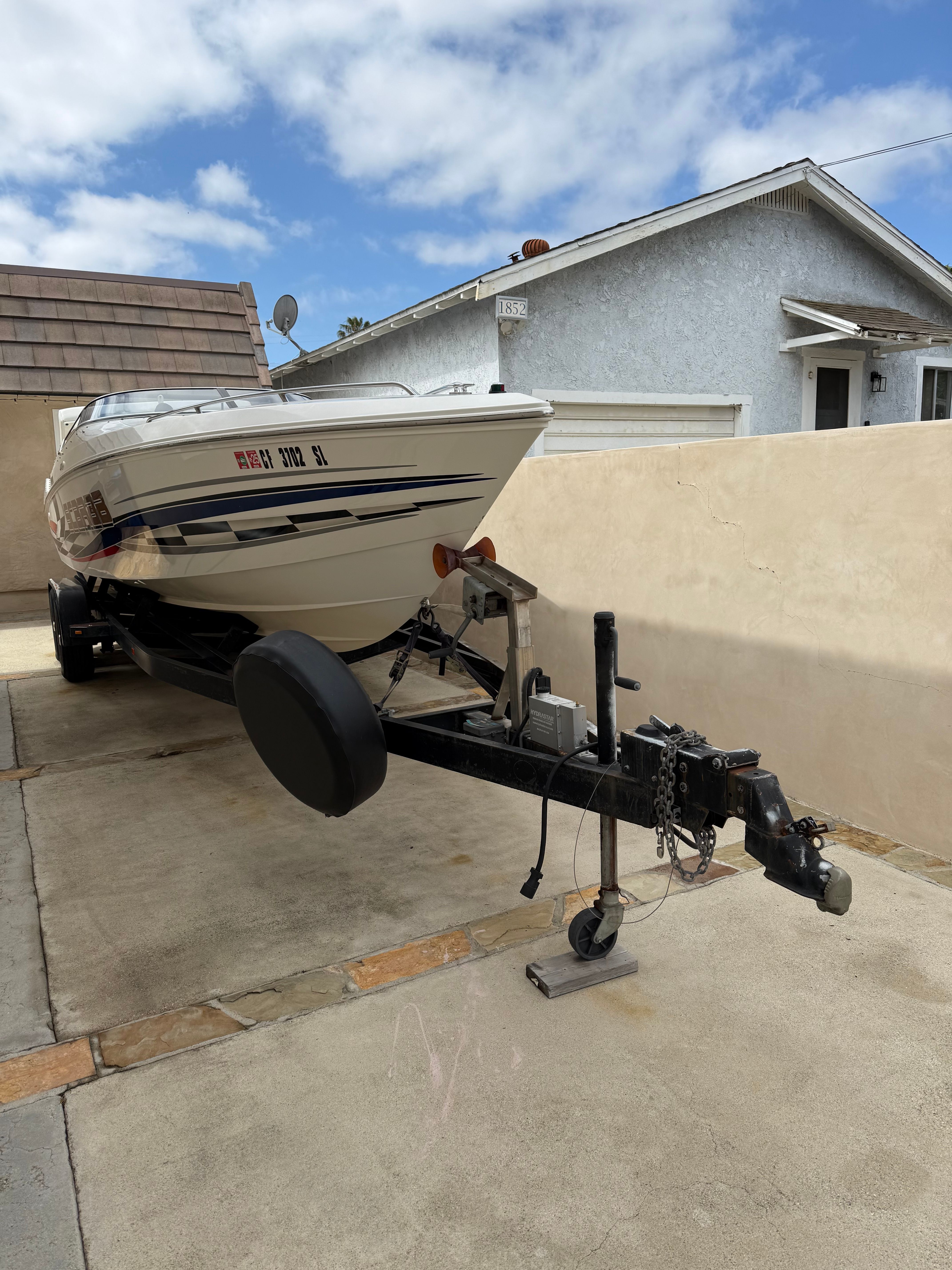 2001 Wellcraft 29 Scarab on trailer in driveway.