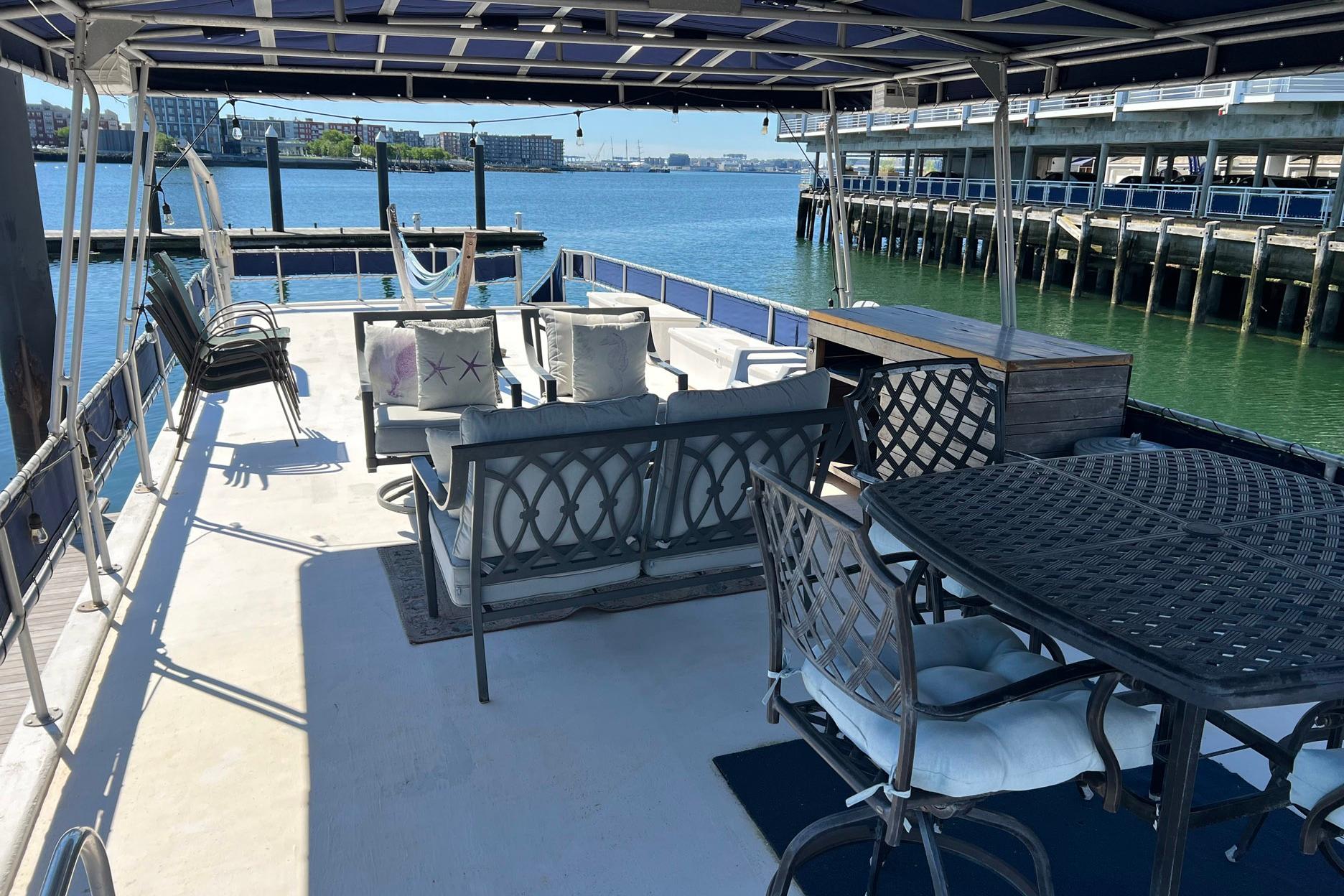 1993 Sumerset houseboat deck with seating, table, and waterfront view.