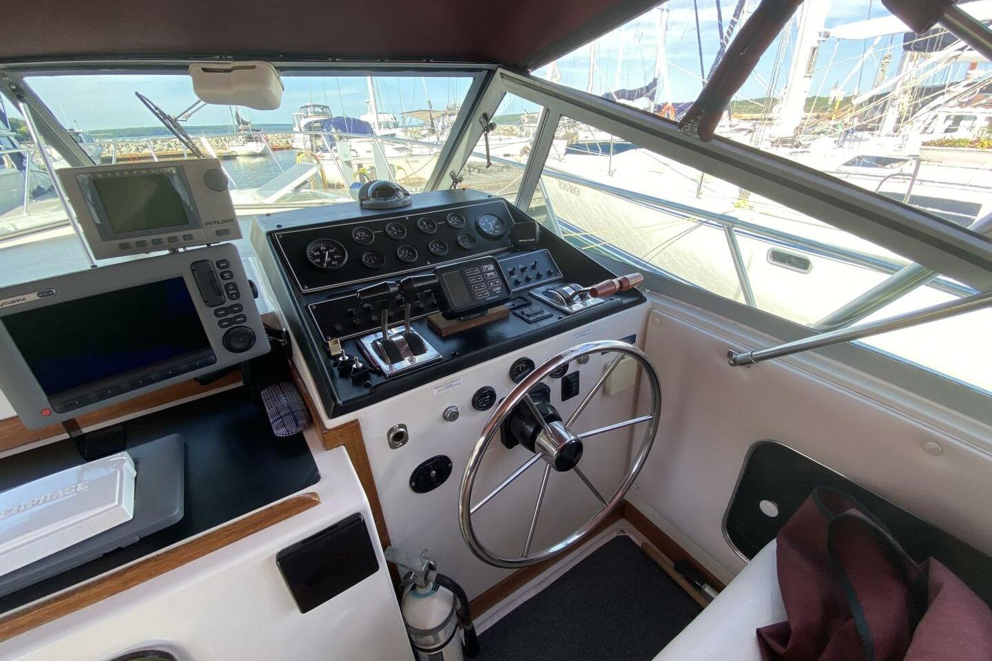 Cockpit of 1988 Chris-Craft 332 Amerosport with navigation equipment and steering wheel.