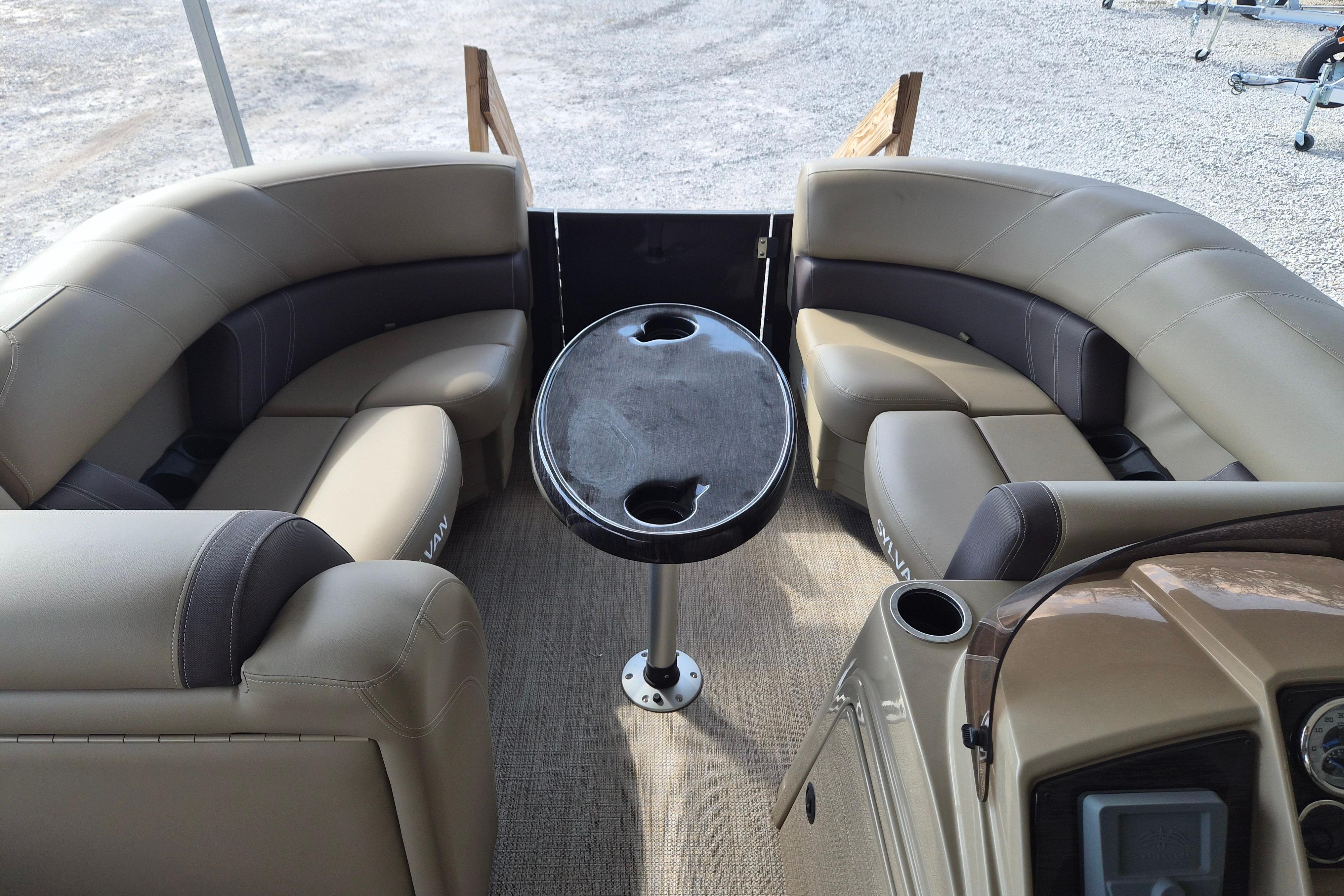 2026 Sylvan Mirage 820 CLZ DH pontoon boat interior with beige seating and central table.