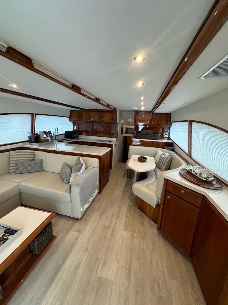 Spacious interior of a 2002 Bertram 510 Convertible yacht with modern furnishings.