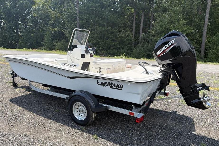 2026 Mako Pro Skiff 15 CC boat with Mercury engine on trailer, parked outdoors.