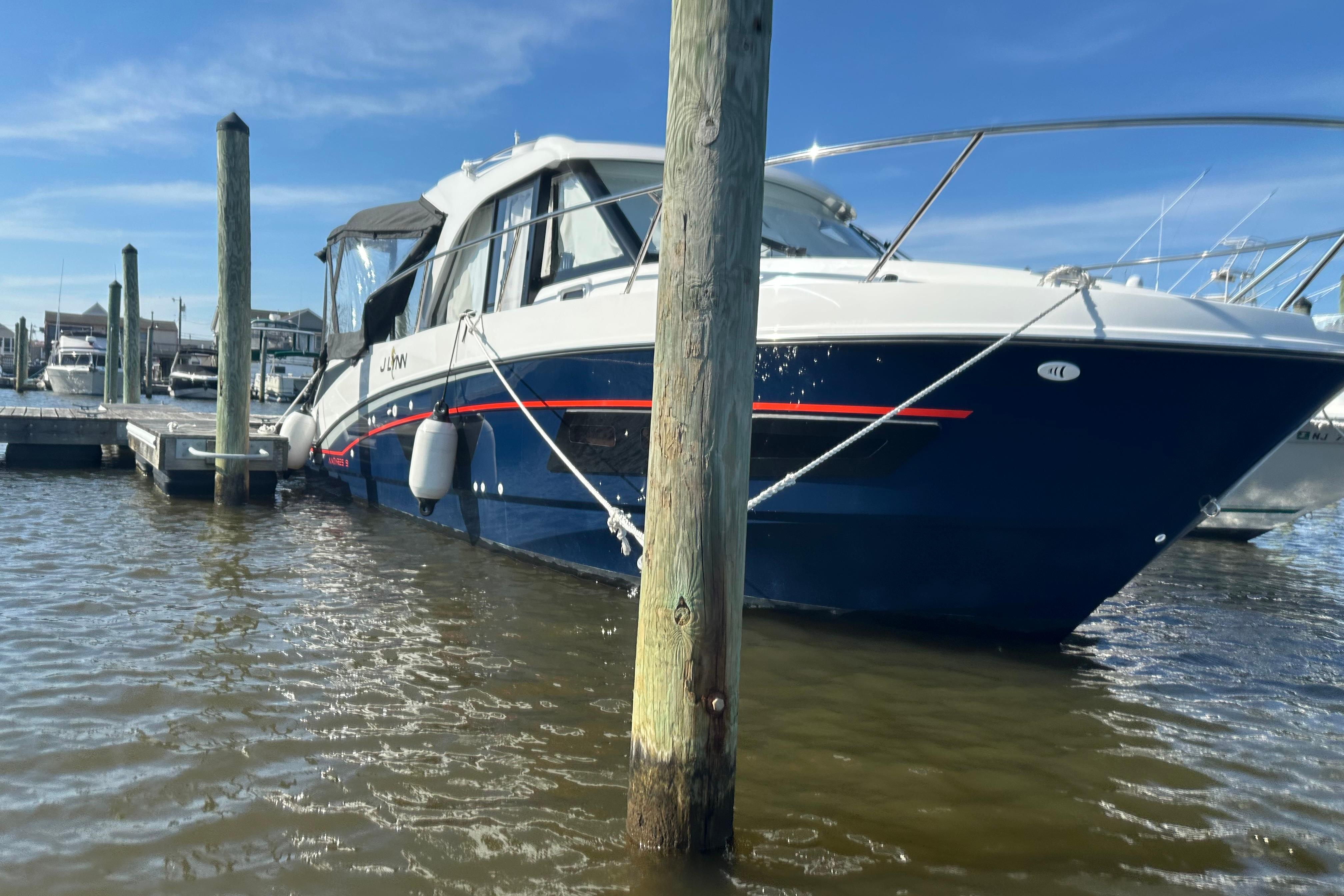 2024 Beneteau Antares 9 docked at marina under clear blue sky.
