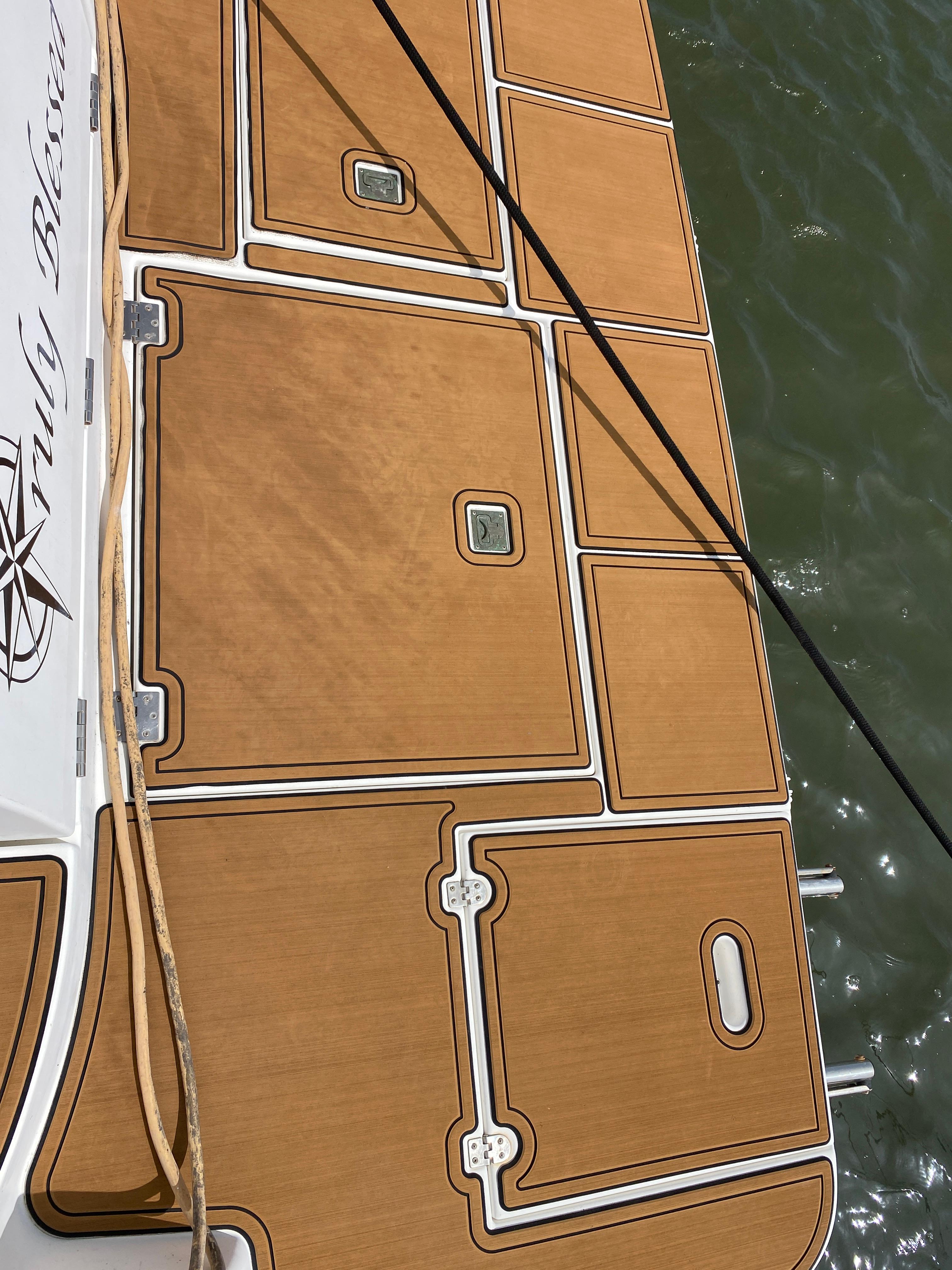 Cruisers 3672 2000 model boat deck with teak flooring, docked on water.