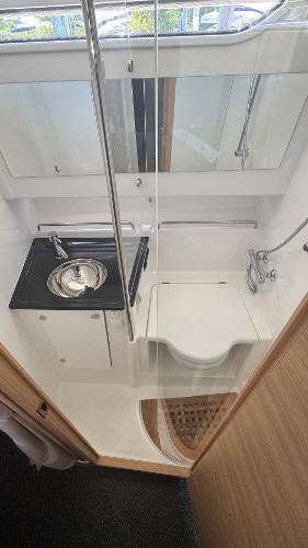 Modern bathroom in 2025 Nimbus T11 boat with sink, toilet, and shower.