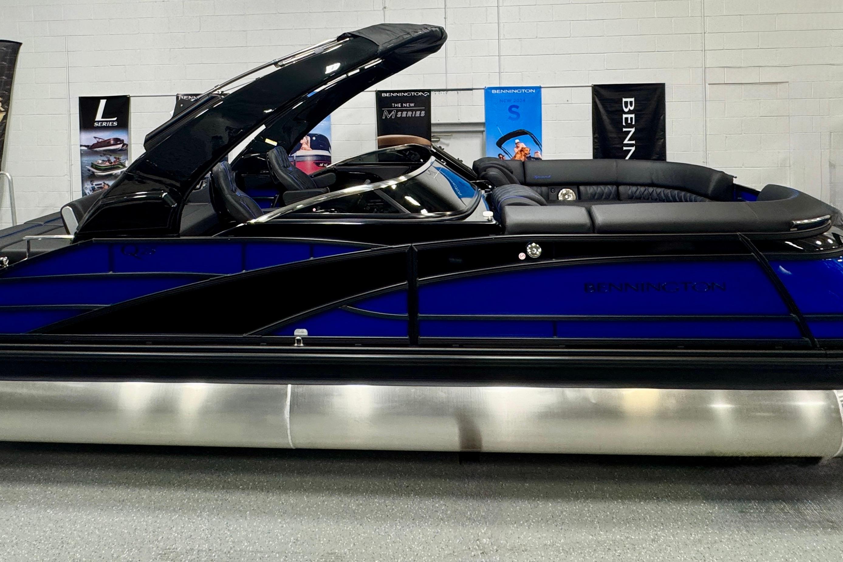 2026 Bennington 25 QSBWASE pontoon boat in showroom, featuring sleek design and luxurious seating.