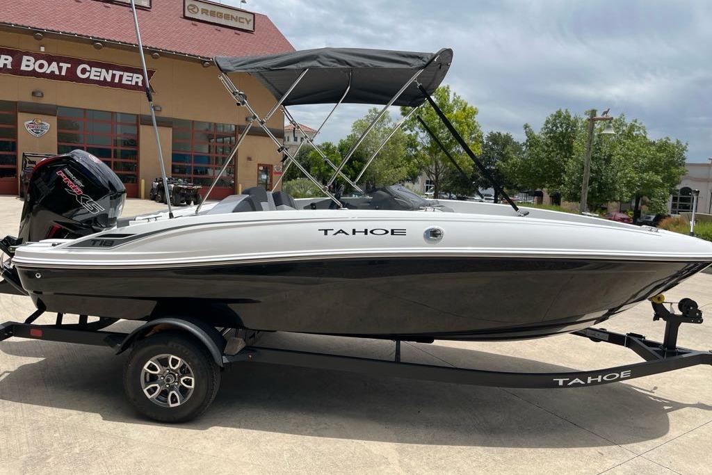 2026 Tahoe T18 boat on trailer at dealership, featuring sleek design and black-and-white color scheme.