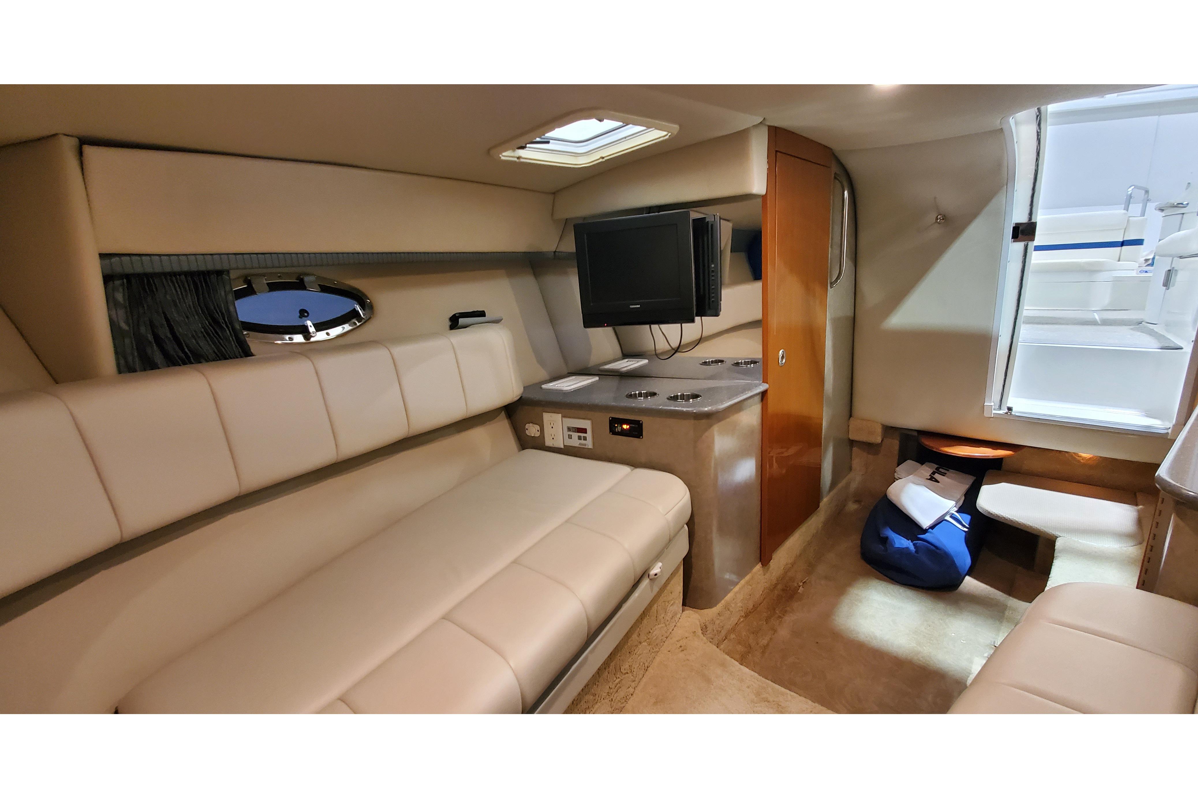 Interior of 2006 Formula 330 Sun Sport boat, featuring beige seating, TV, and compact cabin amenities.