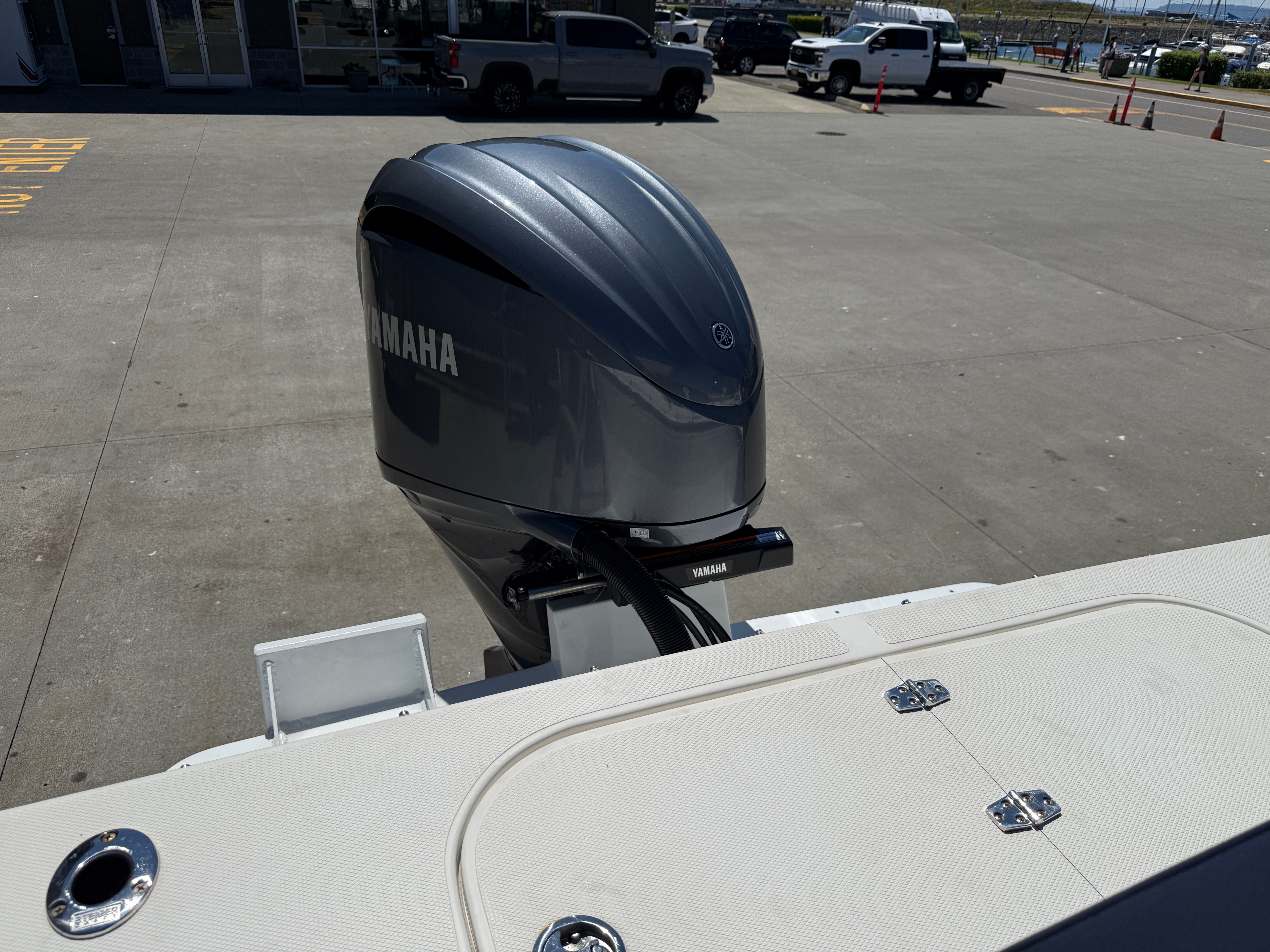 A Yamaha outboard motor is attached to a boat parked in a lot.